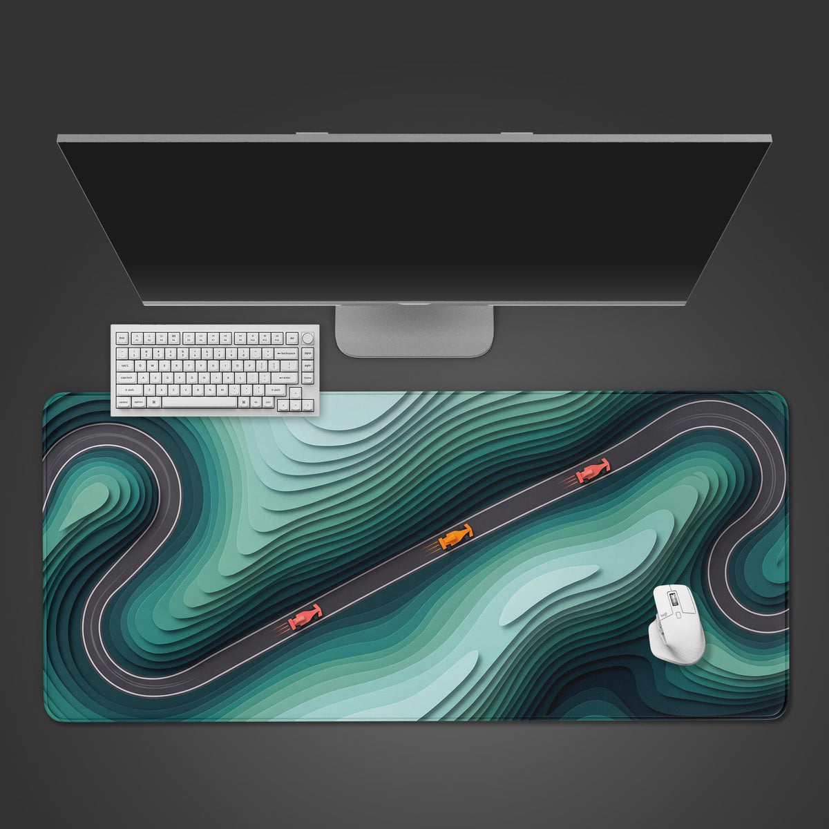 Teal racing abstract desk mat seen from above under a white keyboard and mouse, with three race cars on a winding track
