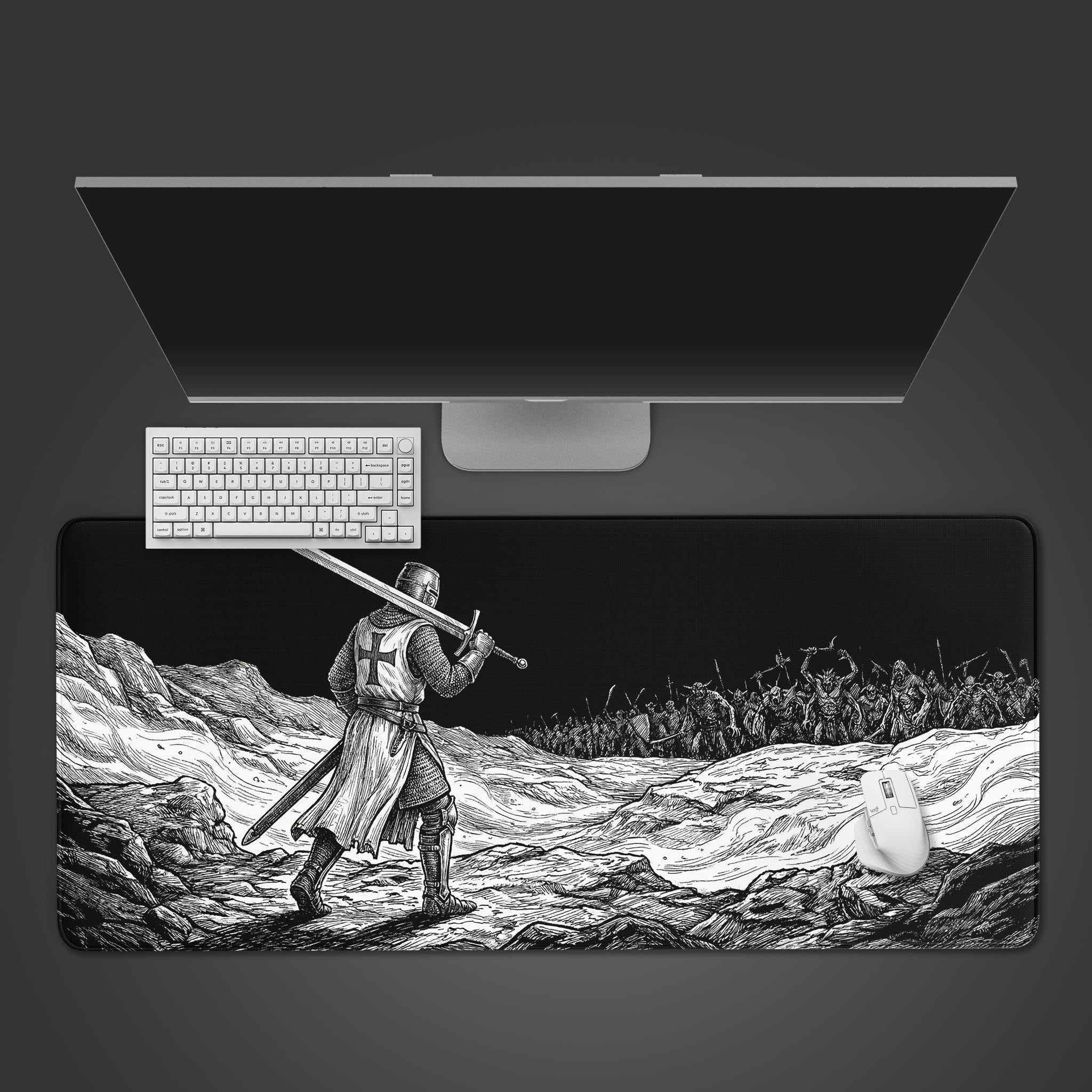 A top-down view of 'The Last Stand' gaming desk mat, showing the knight artwork alongside a white keyboard, mouse, and a large monitor on a clean desk setup. - Epic Design Pads & Mousepads