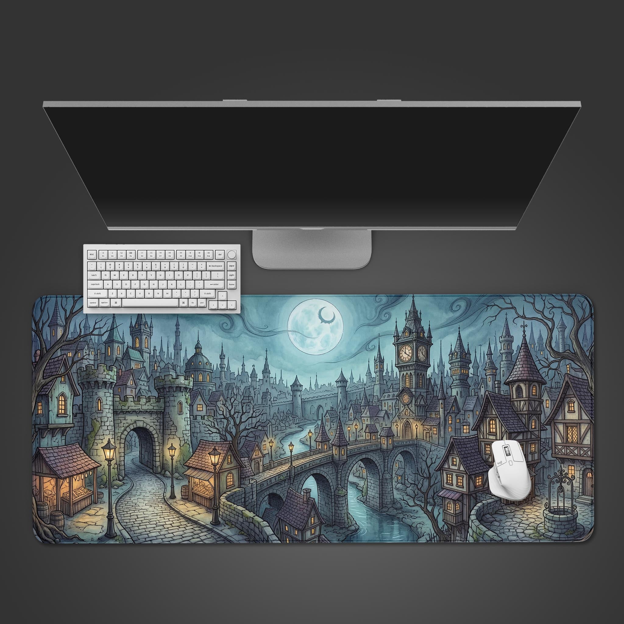 Top-down view of the Twilight Hollow gaming desk mat, featuring a moonlit medieval city design underneath a sleek monitor, white keyboard, and mouse. - Epic Design Pads & Mousepads
