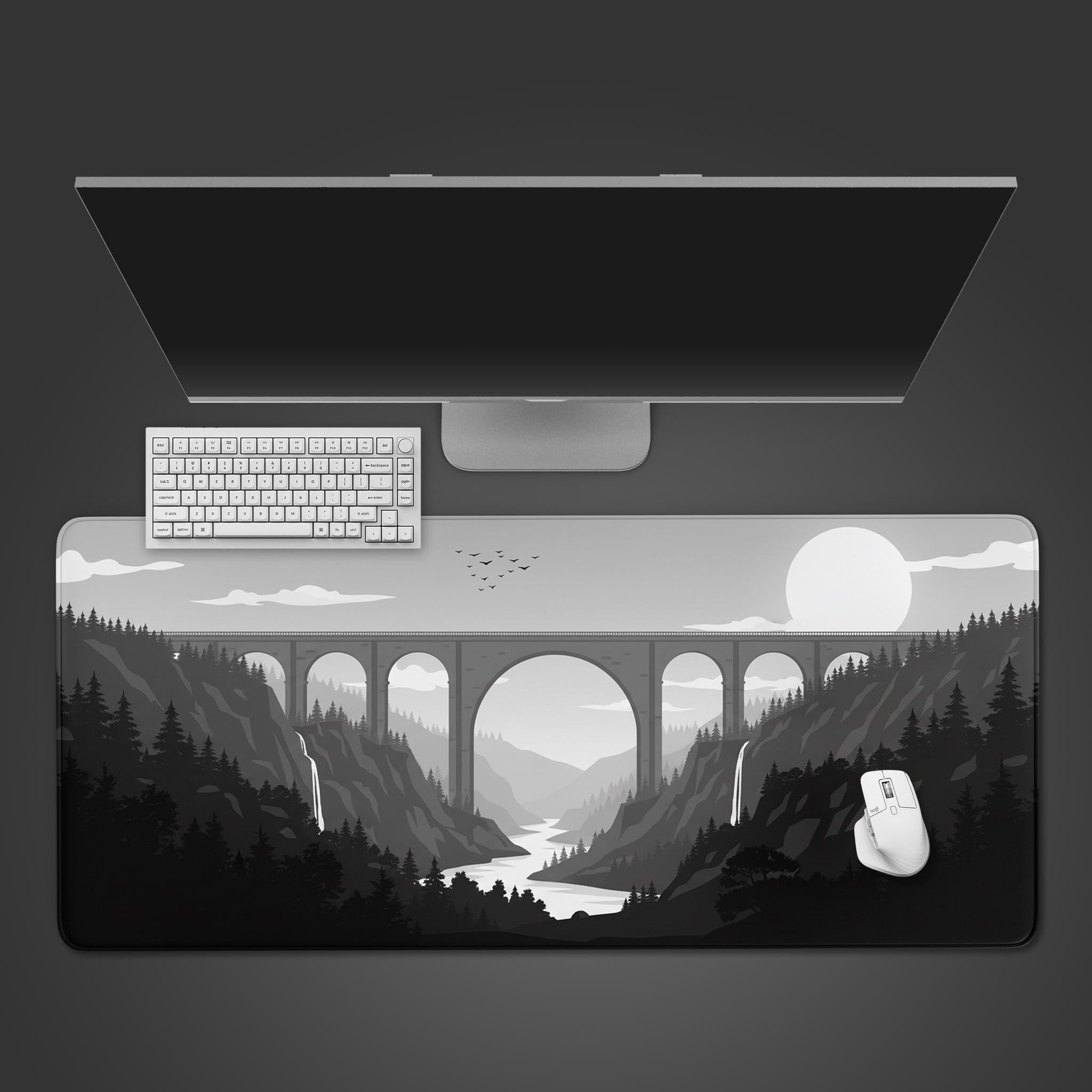 Monochrome viaduct desk mat with a large stone bridge design, shown from a top-down view with a black keyboard and mouse. - Epic Design Pads
