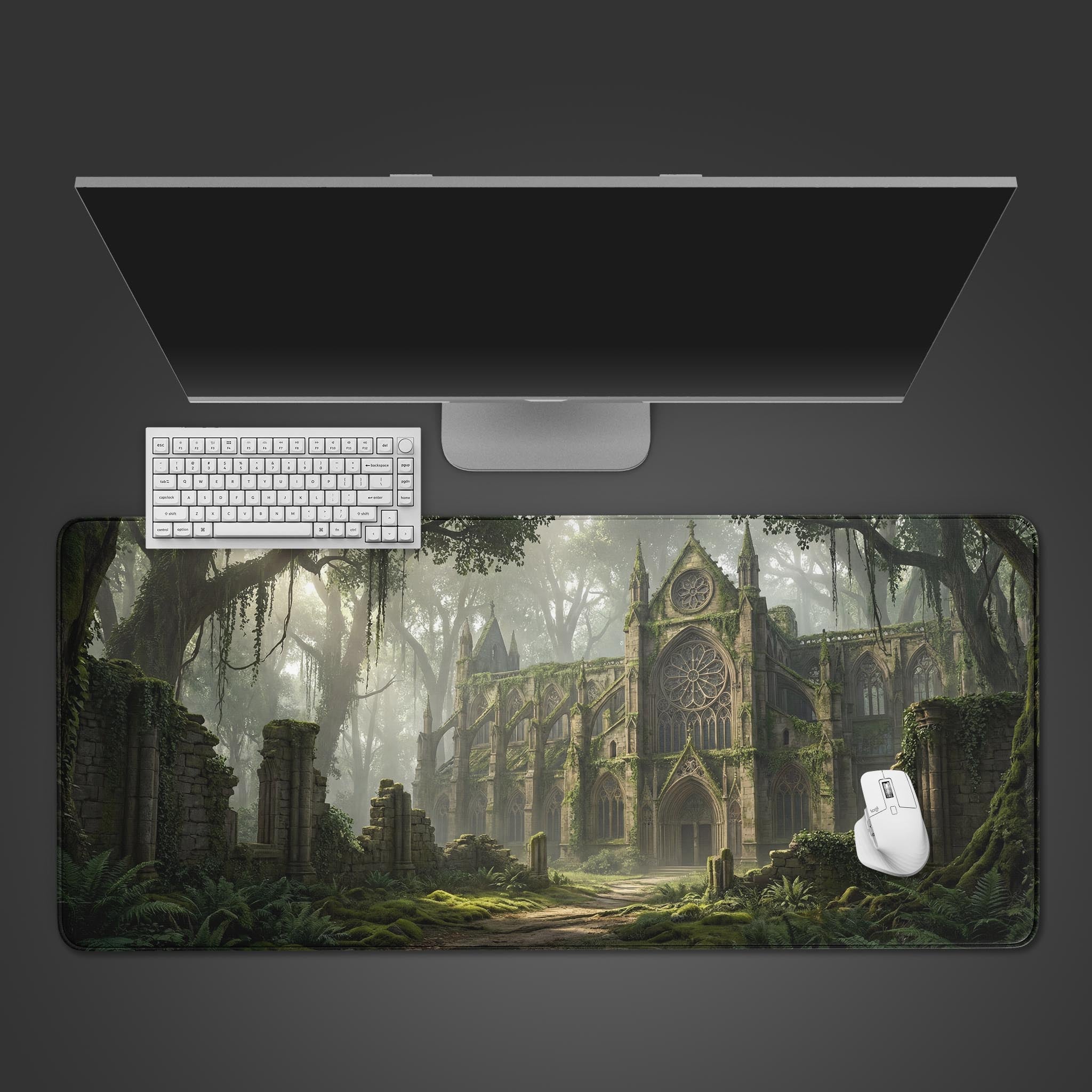 A top-down view of the Verdant Ruins gaming desk mat, showcasing its overgrown cathedral art beneath a sleek monitor, white keyboard, and mouse. - Epic Design Pads & Mousepads