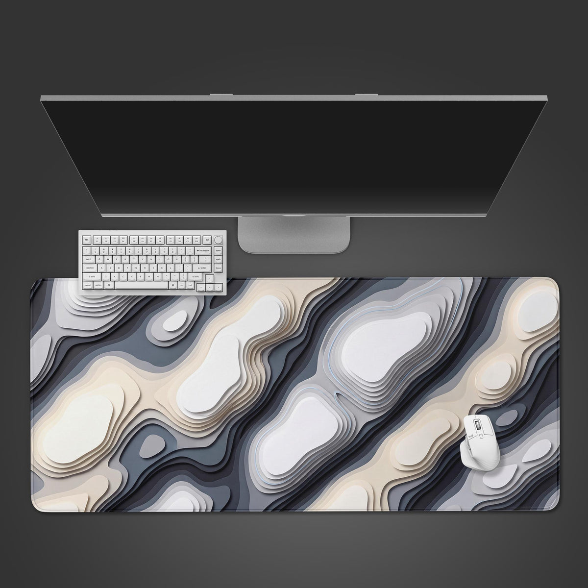 Overhead view of a white camo abstract desk mat with white, beige and slate contours, a monitor, white keyboard and mouse