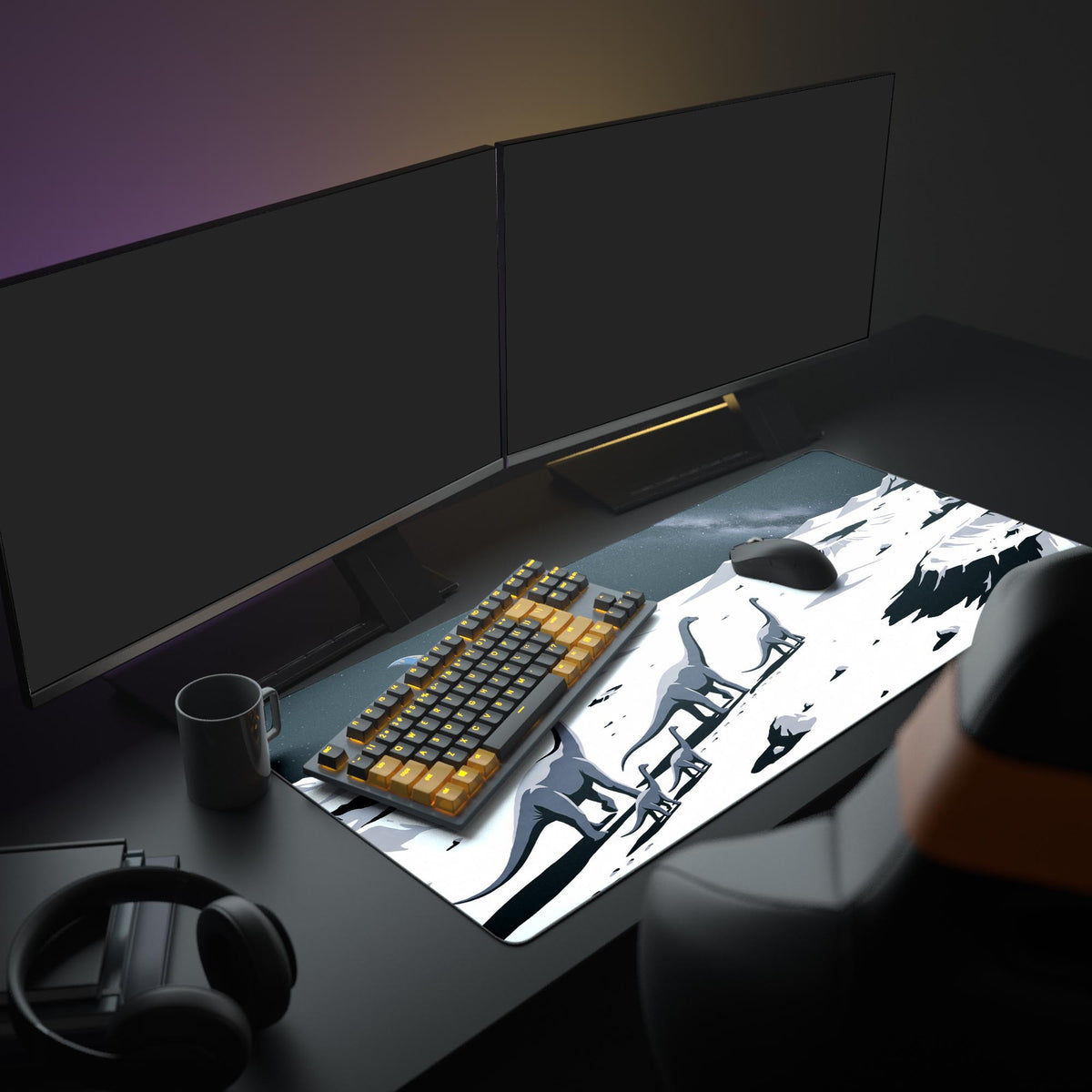 Dinosaur moonscape desk mat on a dark desk under two monitors, with an orange-black keyboard, mouse, mug and headphones