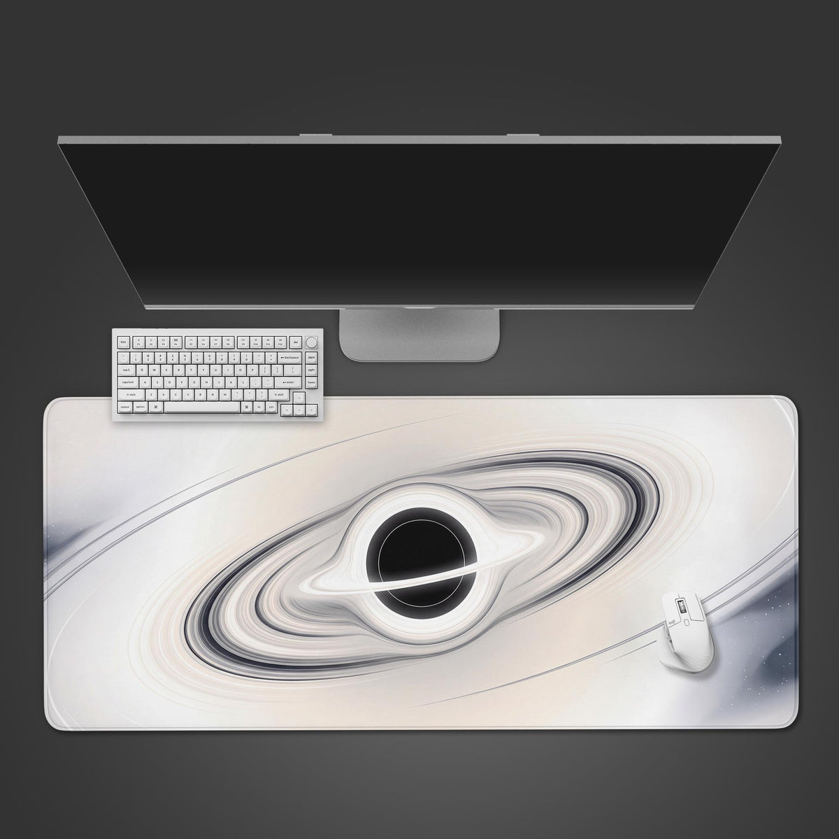 Top view of a white full moon black hole space desk mat with ivory rings, a white keyboard, monitor and white mouse
