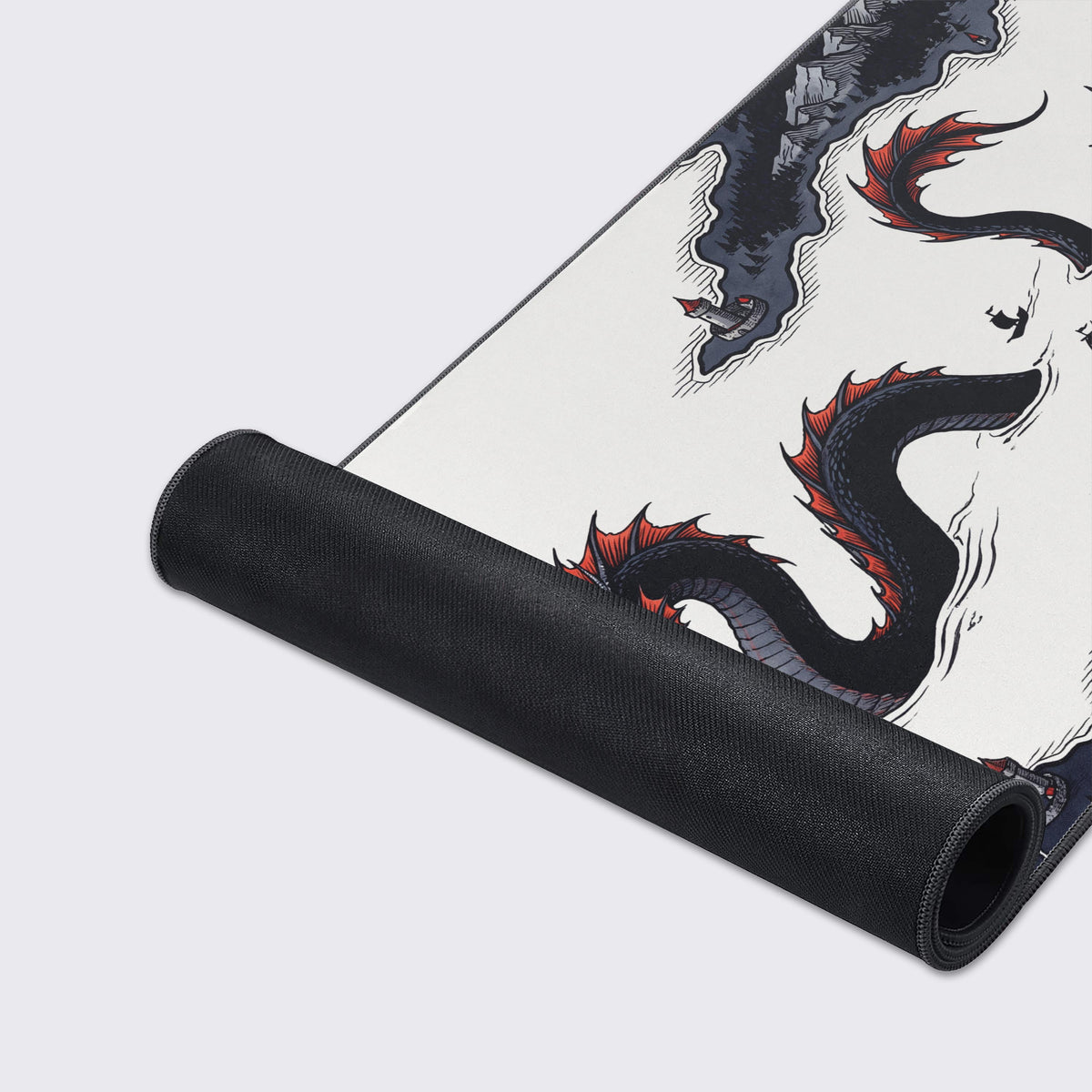 Desk mat partly rolled up showing its black rubber underside below the black and red sea serpent and coastline art