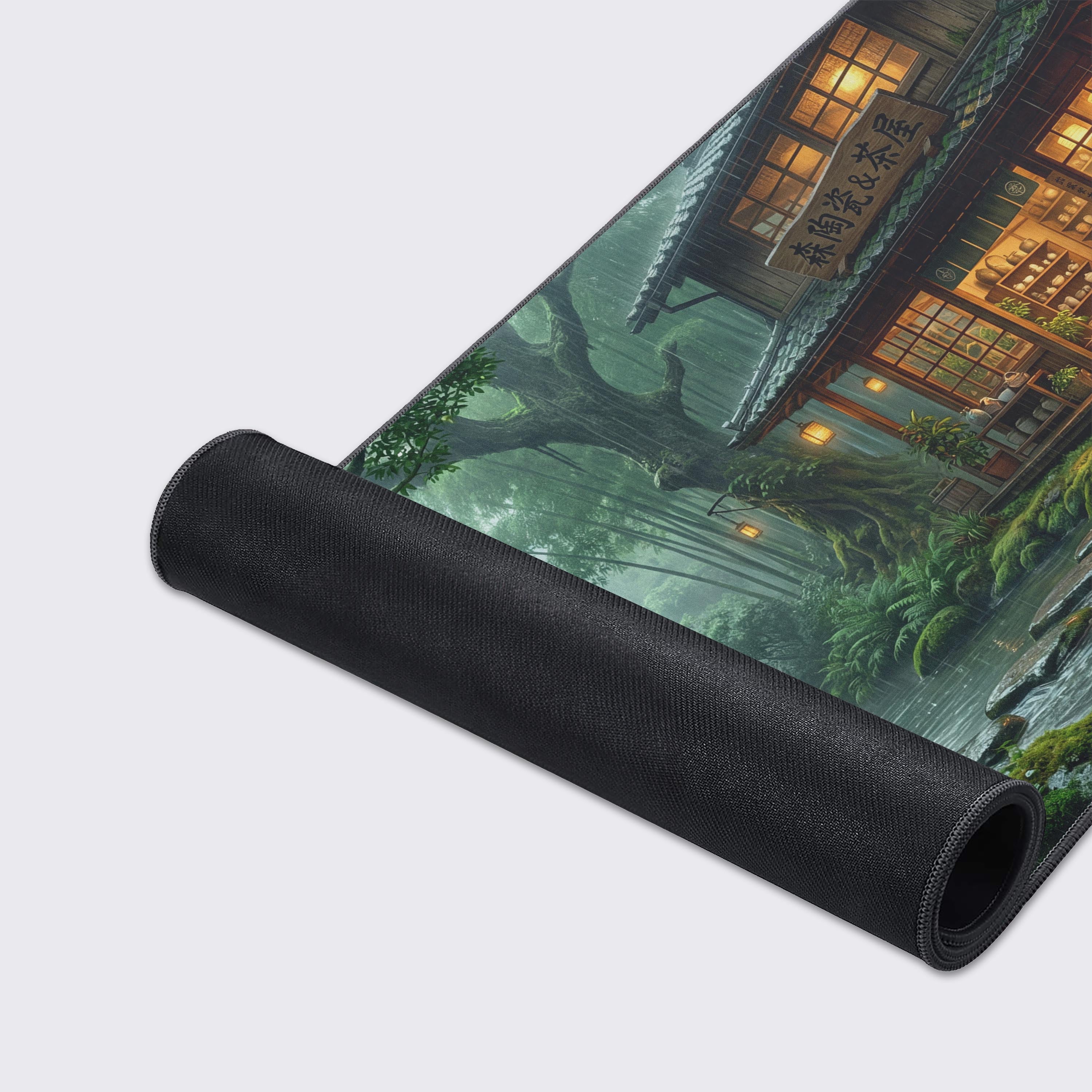 A close-up of the Rainy Tea House gaming desk mat, showcasing the durable stitched edges and the detailed artwork of the tranquil, rainy forest stream. - Epic Design Pads & Mousepads