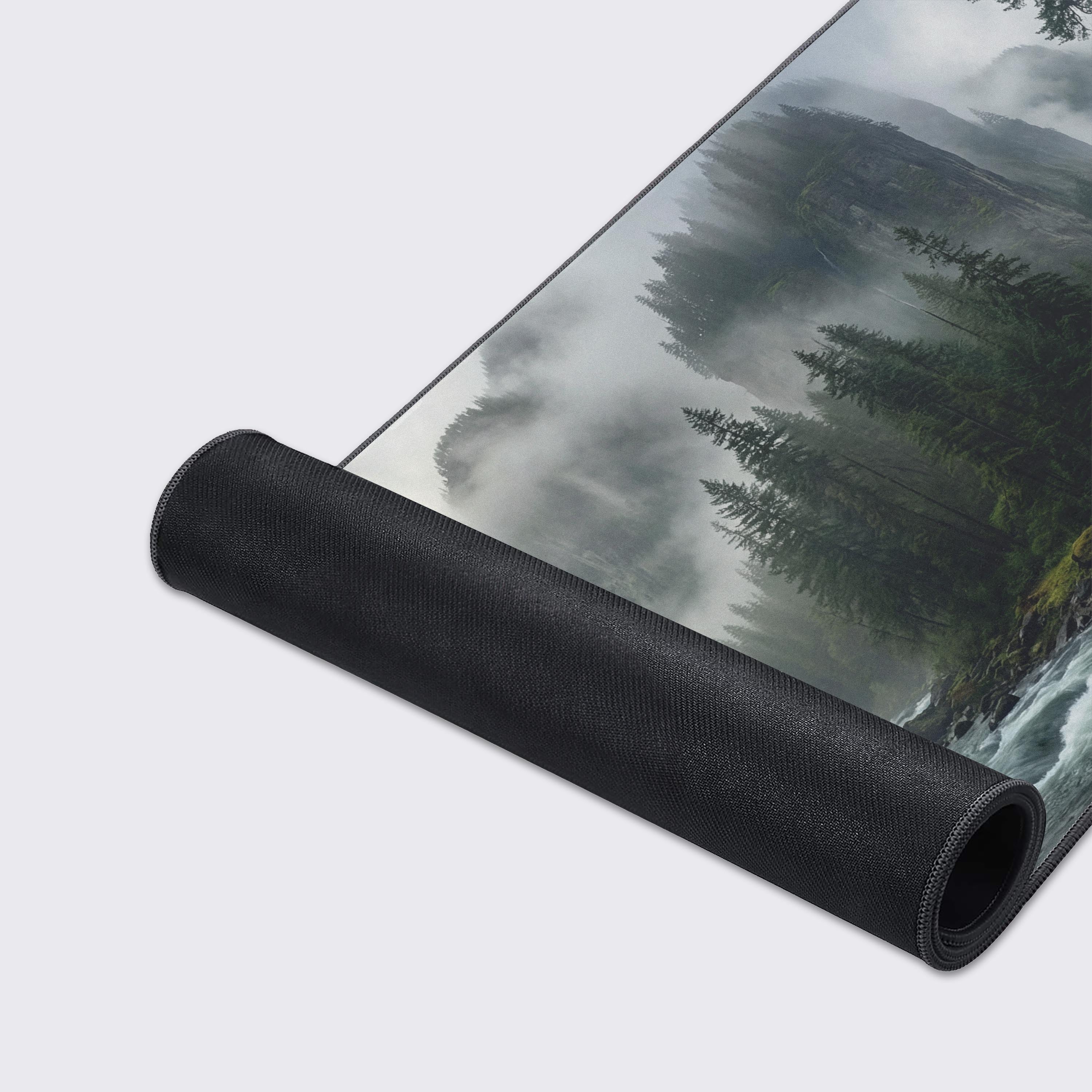 A close-up of the Silent Valley gaming desk mat, highlighting the high-quality fabric texture and durable stitched edges over the beautiful misty river and forest artwork. - Epic Design Pads & Mousepads