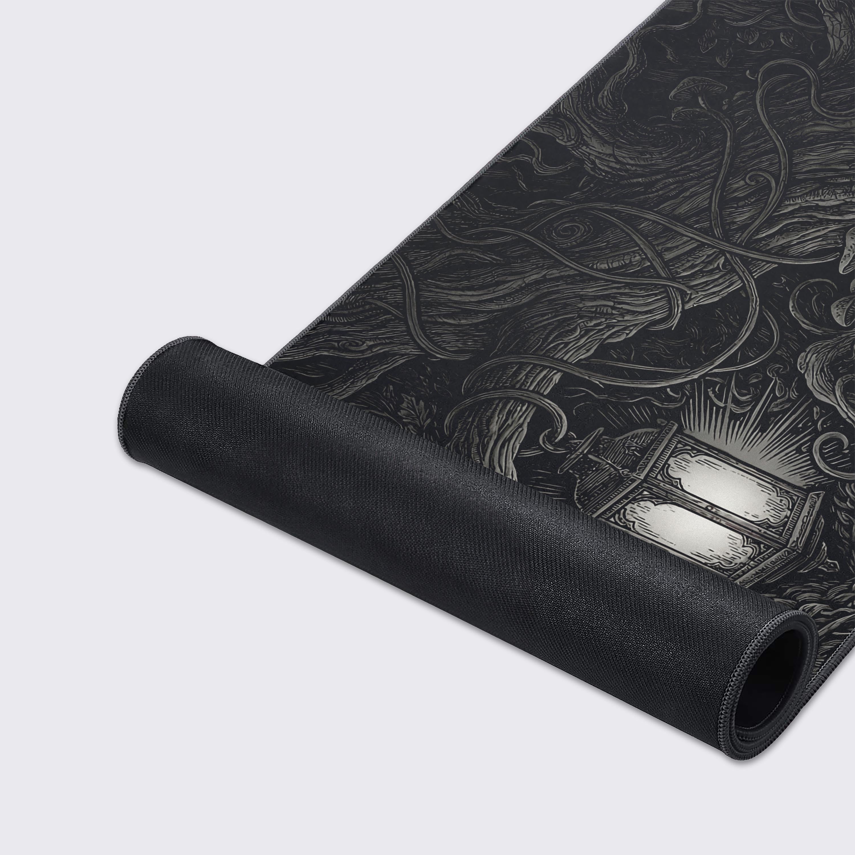 A close-up of the Nocturnal Roots Gaming Desk Mat, highlighting the detailed woodcut-style art and durable stitched edges on the smooth, non-slip surface. - Epic Design Pads & Mousepads