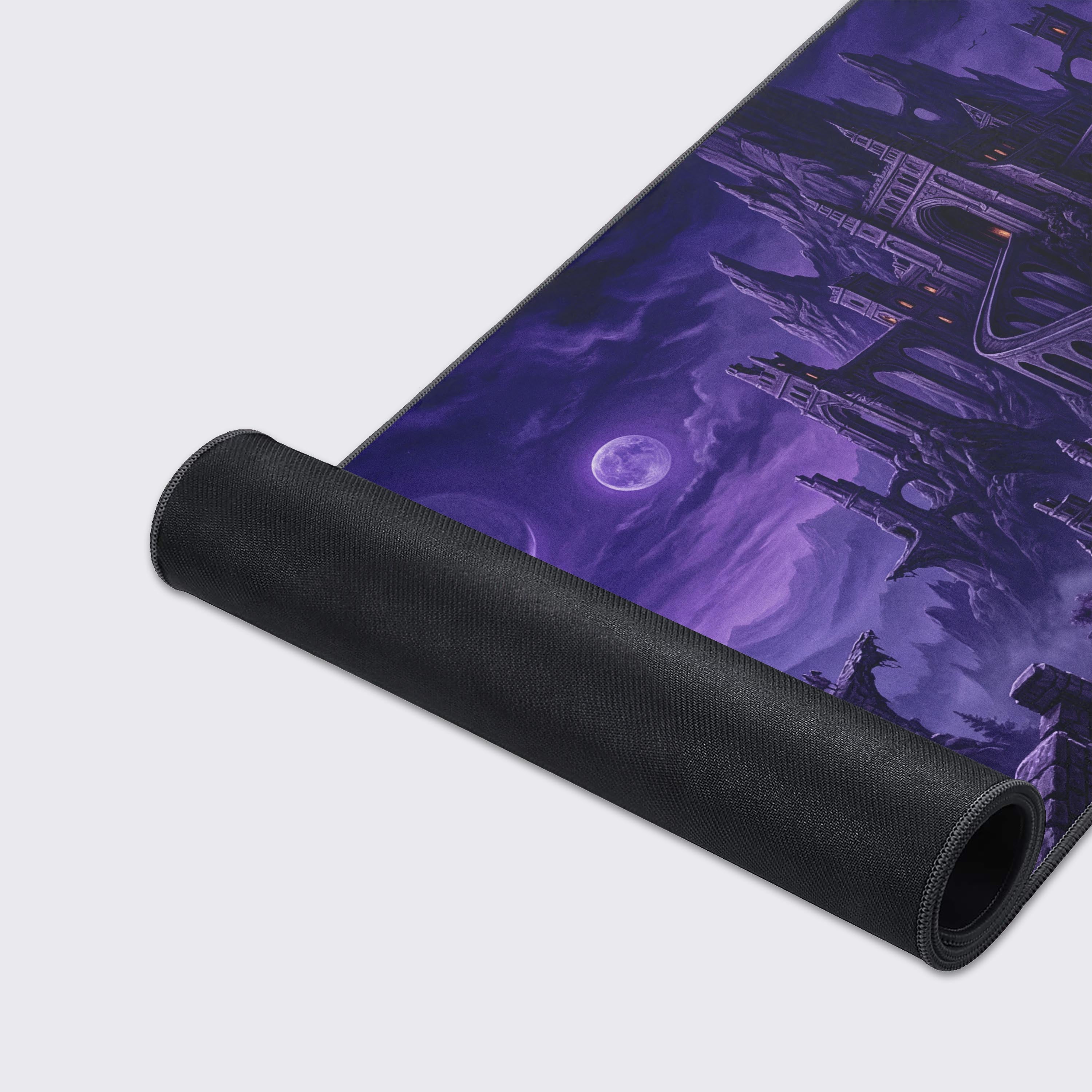 A close-up of the Nocturnal Citadel gaming desk mat, highlighting the smooth fabric texture and durable stitched edges of the purple fantasy castle artwork. - Epic Design Pads & Mousepads
