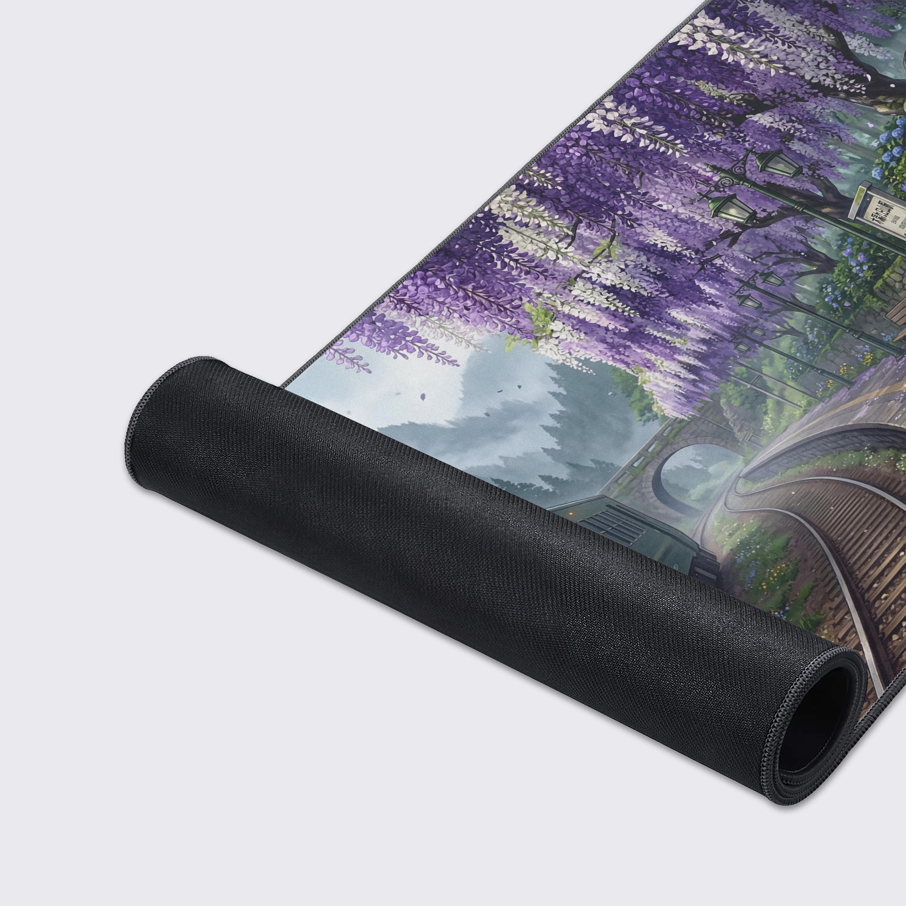 A close-up of the Quiet Departure mouse pad's high-quality texture and stitched edges, highlighting the vibrant purple wisteria and green train artwork. - Epic Design Pads & Mousepads