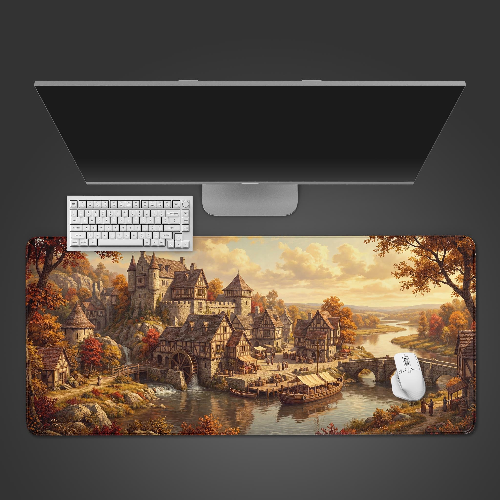 Top-down view of the Autumn River Hamlet gaming desk mat, showcasing the medieval village artwork beneath a sleek monitor, white keyboard, and white mouse. - Epic Design Pads & Mousepads
