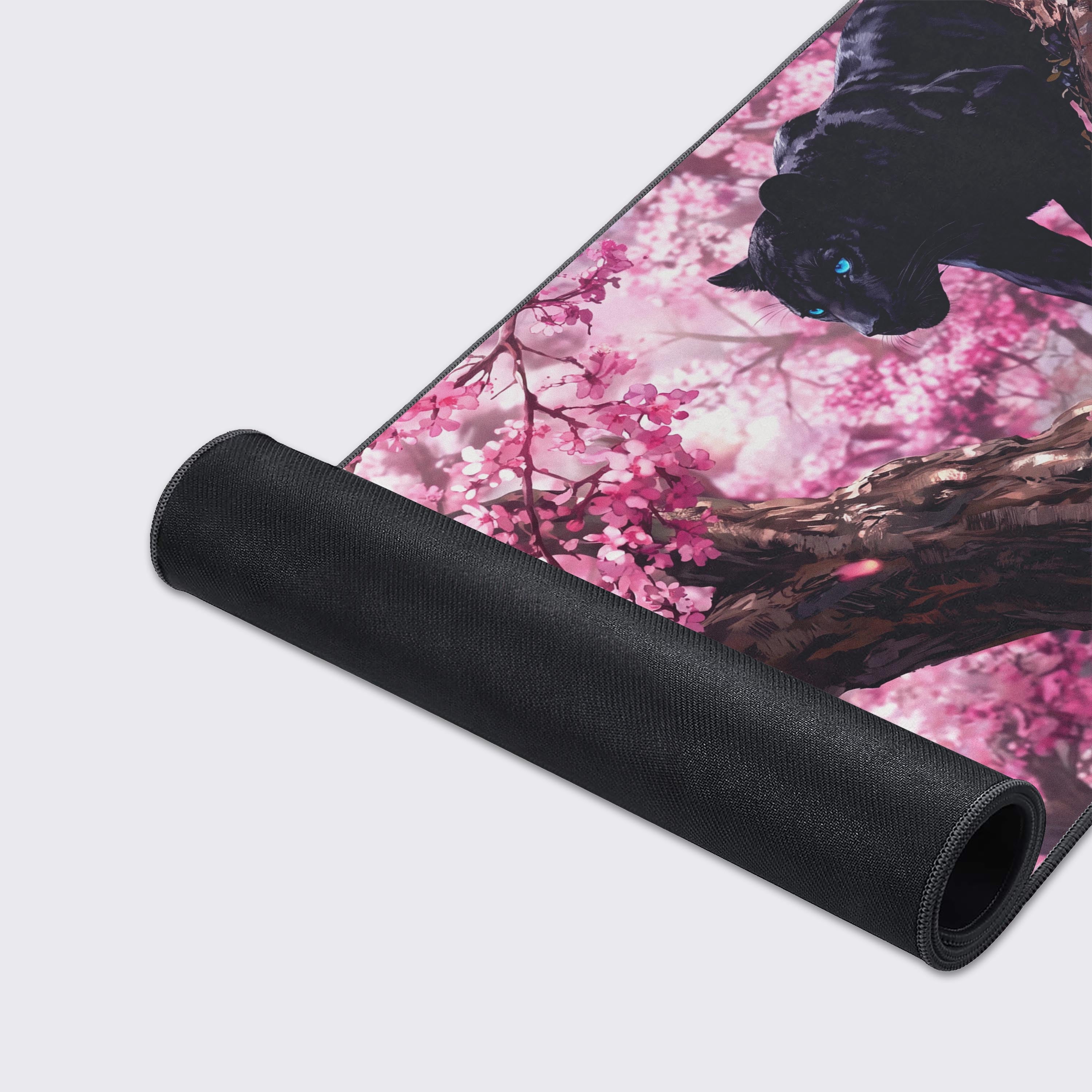 Detailed view of the thick brown tree bark and delicate pink cherry blossom petals on the desk pad