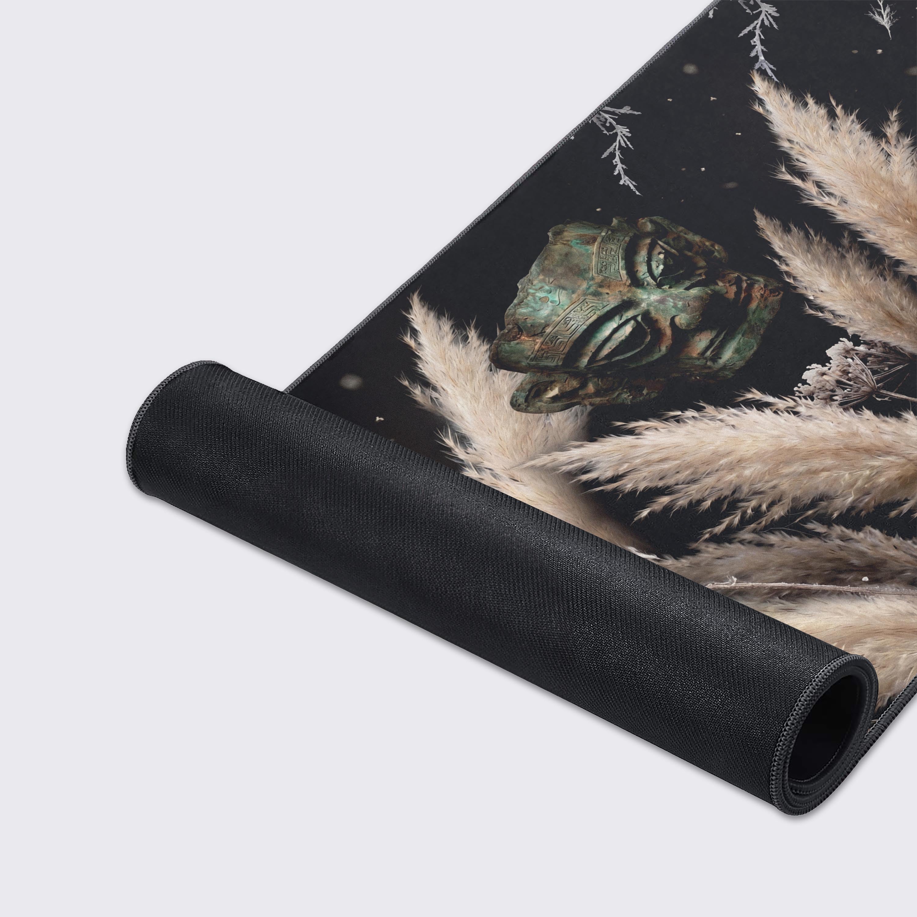 Macro view of frost-covered botanicals and an ancient artifact printed on a smooth desk mat