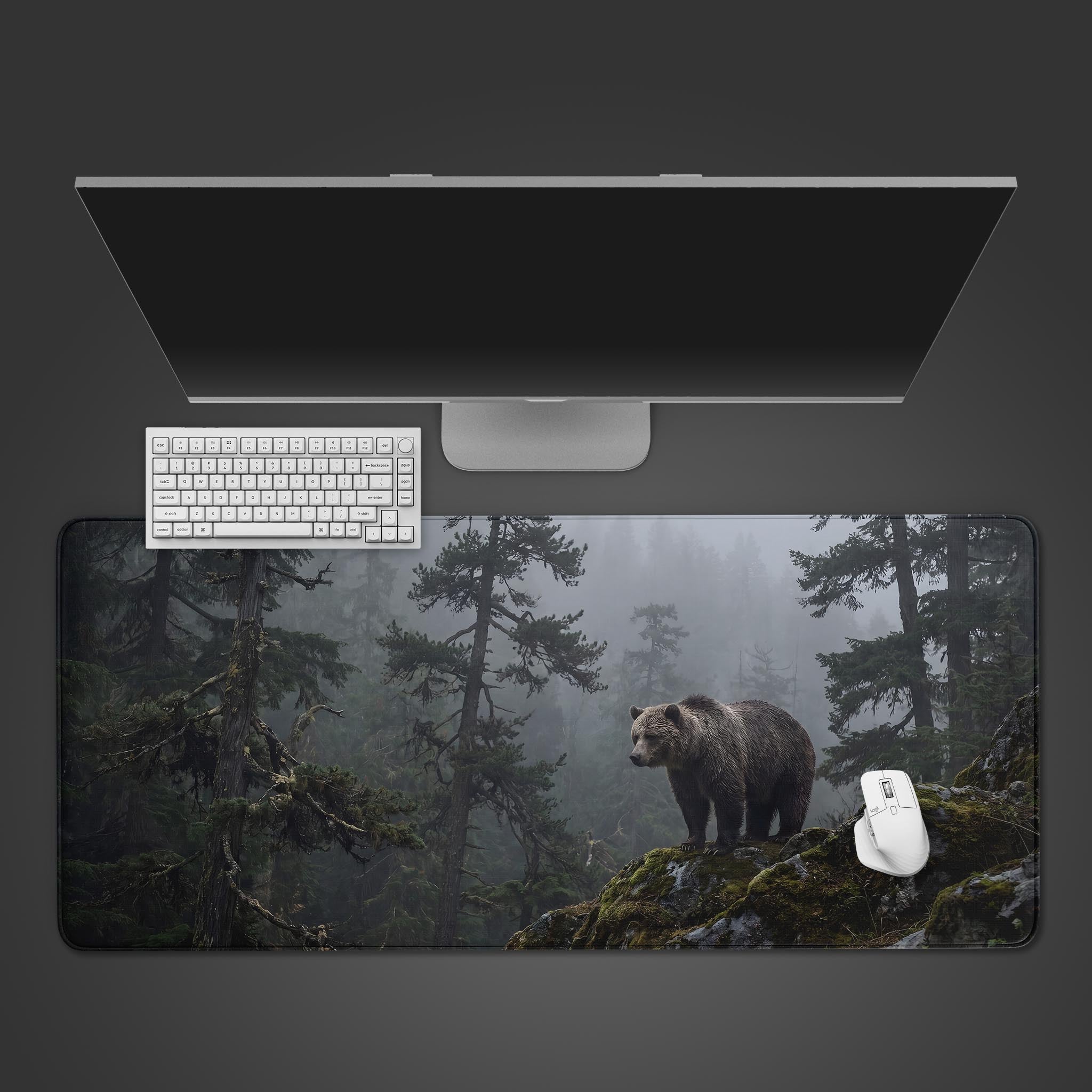 Large desk mat featuring a majestic brown bear standing on a moss-covered rock in a foggy pine forest.