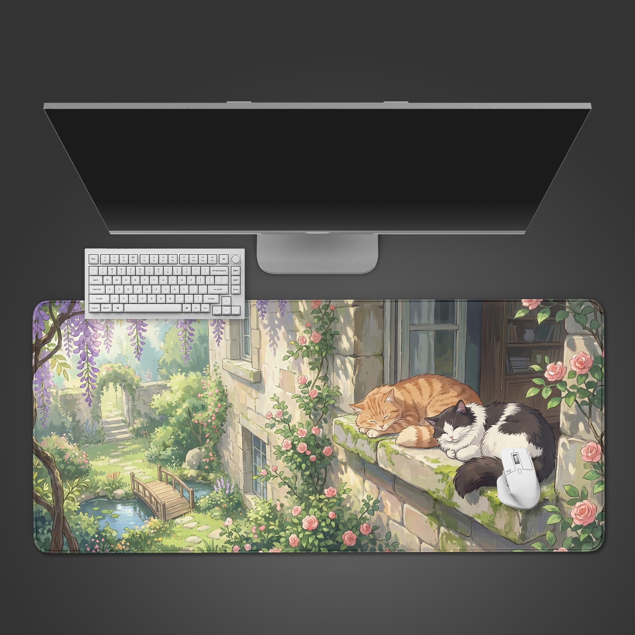 A serene desk mat featuring two cats sleeping on a stone cottage window ledge surrounded by pink roses and purple wisteria.