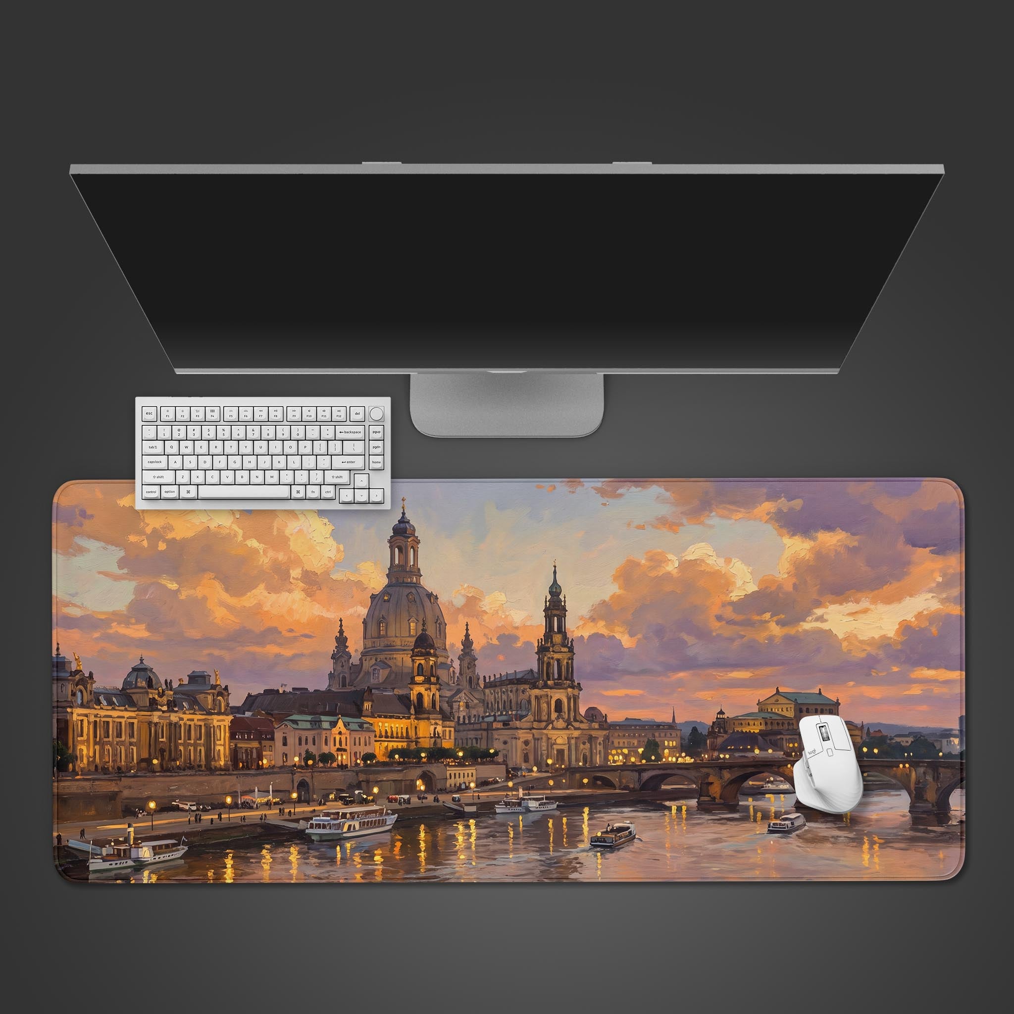 A desk mat displaying a painted European city skyline with a large domed cathedral and river at sunset.