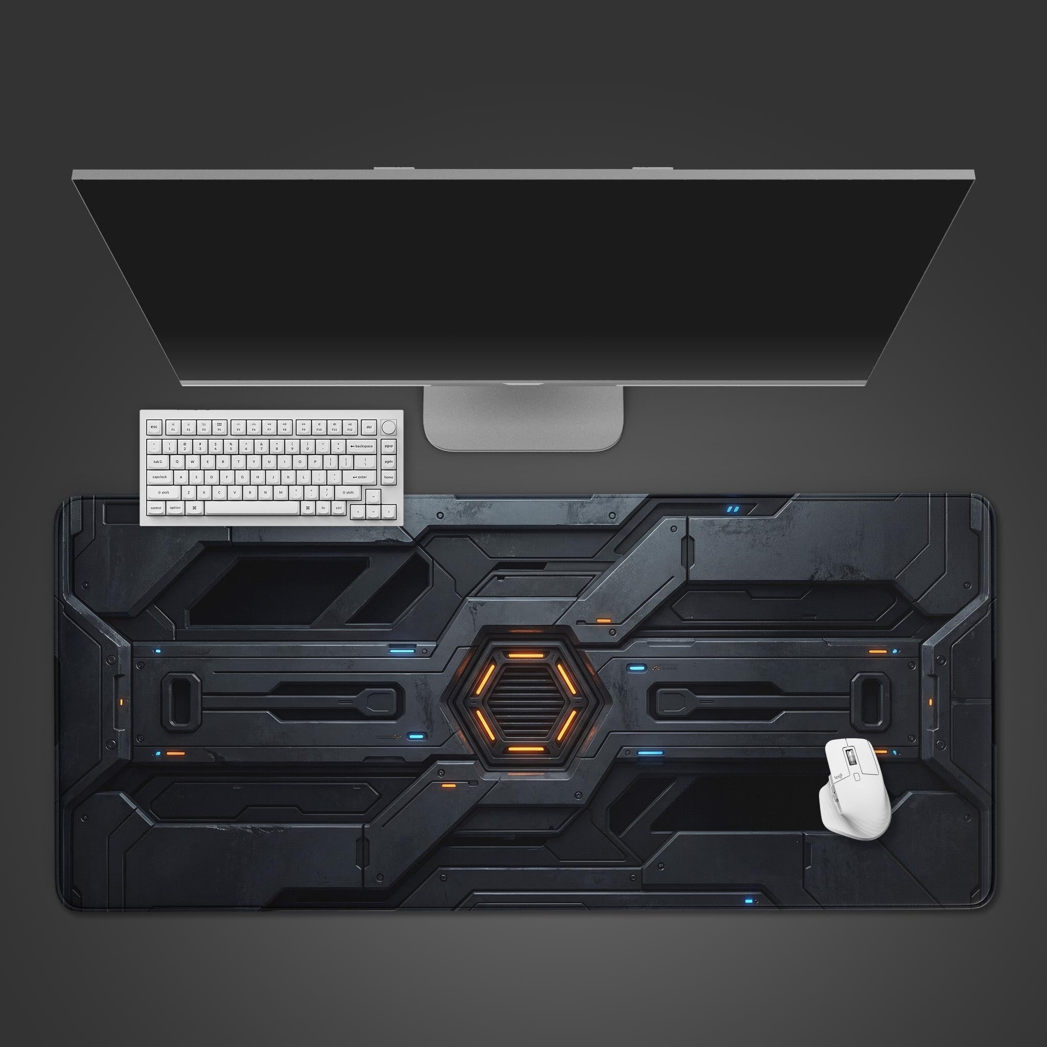 Top-down view of the Core Reactor gaming desk mat, showing its futuristic armor design beneath a sleek white keyboard, mouse, and monitor on a gray background. - Epic Design Pads & Mousepads