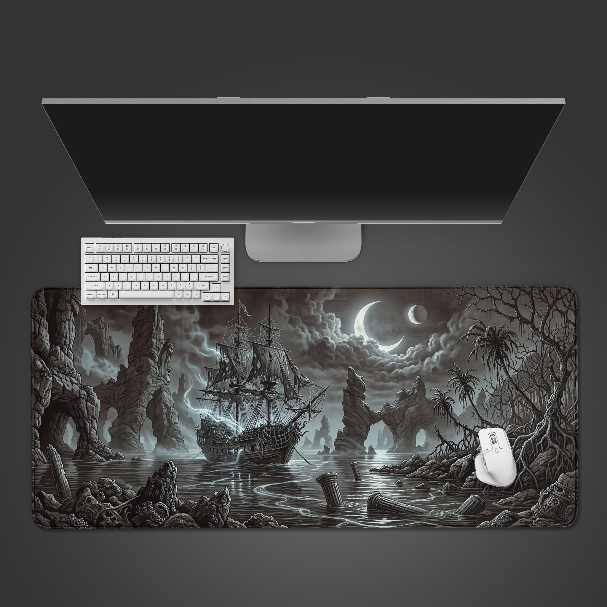 A top-down view of the Cursed Sails gaming desk mat featuring a ghost ship. A white keyboard, mouse, and a monitor are placed on the mat, showcasing a clean, atmospheric setup. - Epic Design Pads & Mousepads