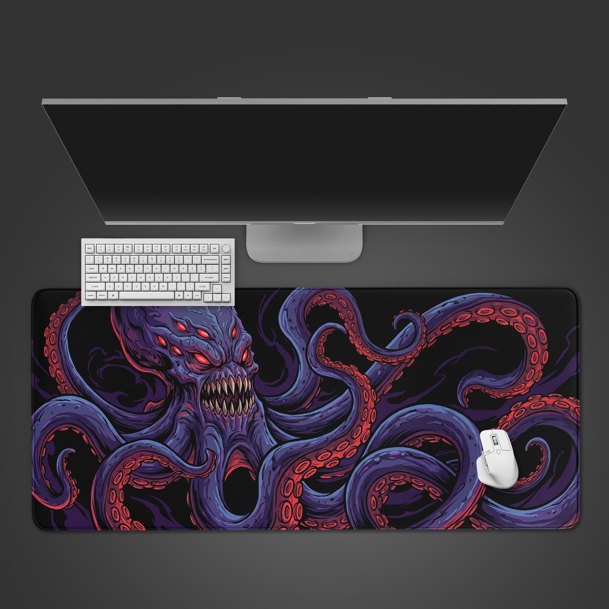 Top-down view of the Deep Terror gaming desk mat featuring a purple Kraken monster, shown with a white keyboard, mouse, and a large monitor on a dark surface. - Epic Design Pads & Mousepads