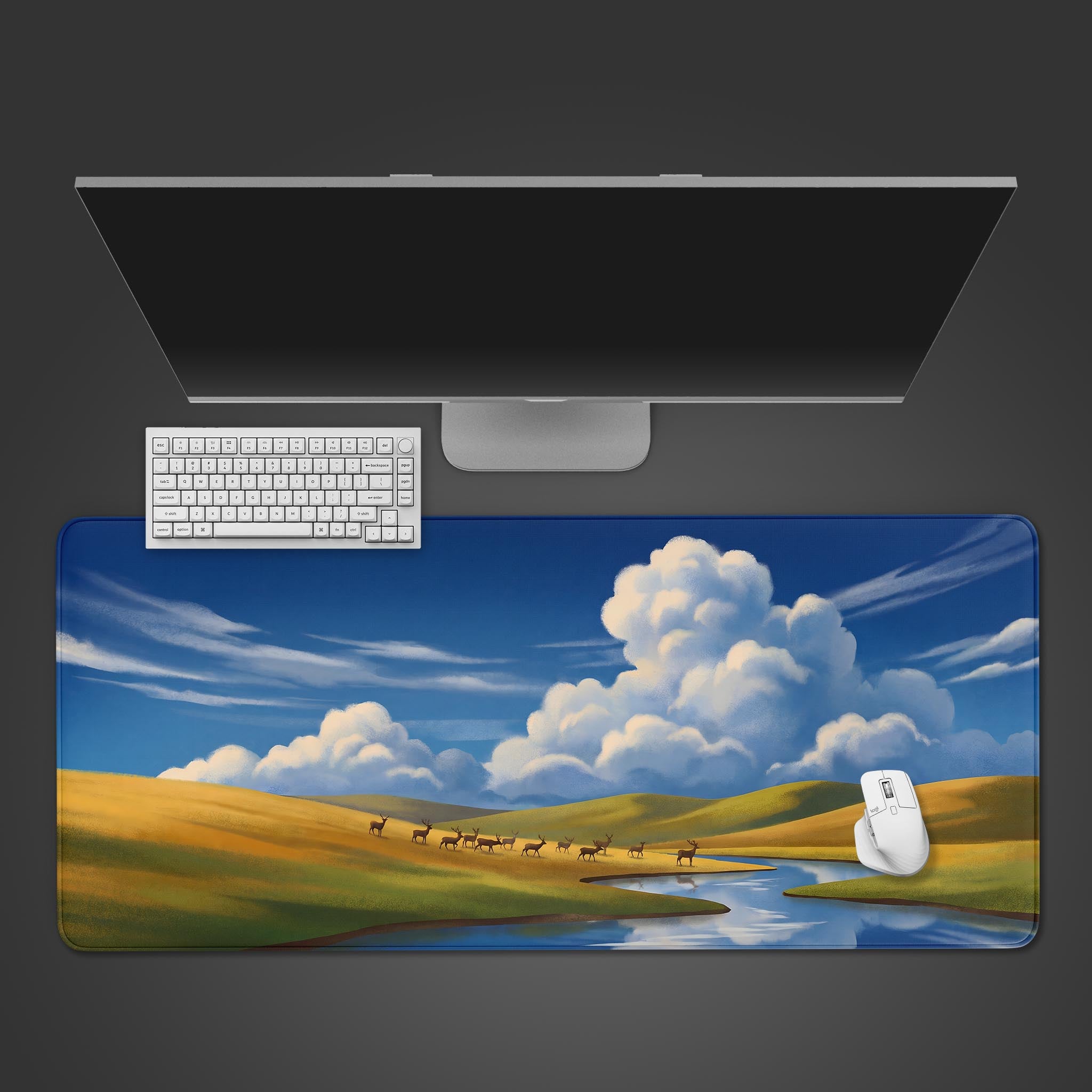 A serene pastoral landscape desk mat featuring rolling green and yellow hills, a winding blue river, and a herd of deer beneath massive white clouds.