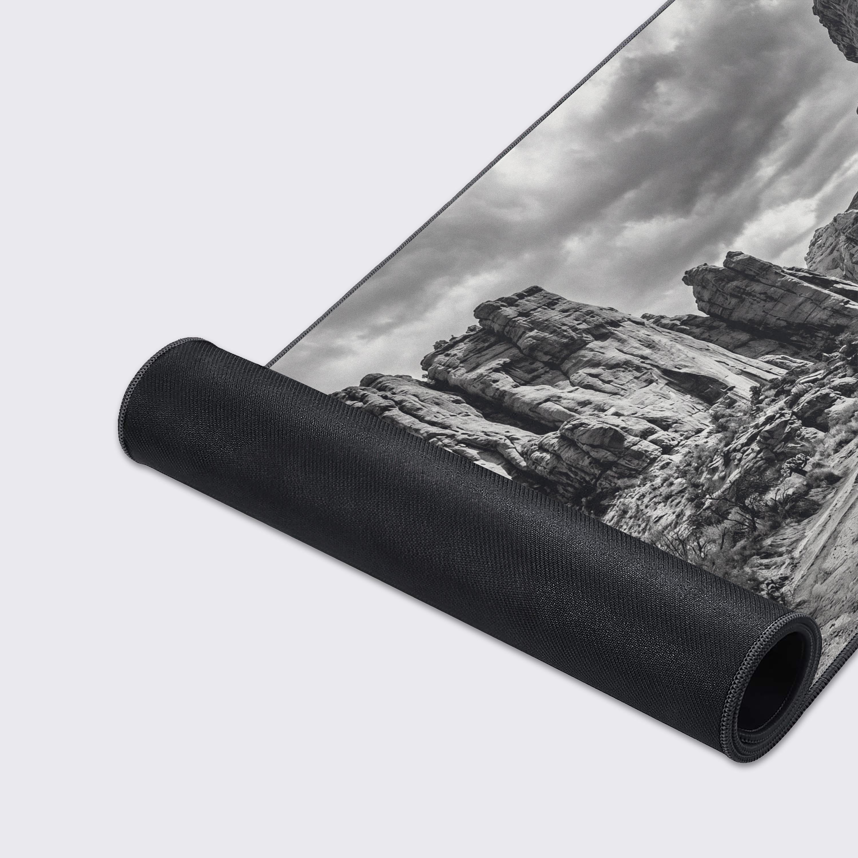 A smooth desk mat with a black and white desert photography aesthetic showing waterproofing and non-slip features