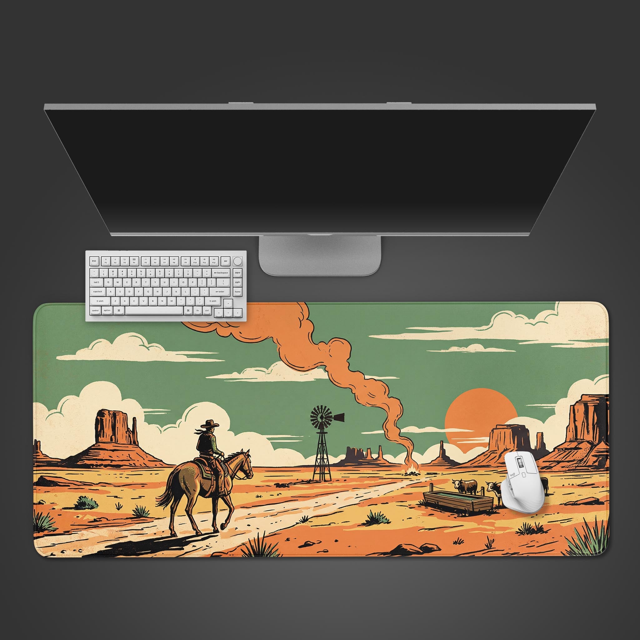 The Dust & Glory Gaming Desk Mat viewed from above, showcasing its retro western cowboy design with a keyboard and mouse placed on top, under a large monitor. - Epic Design Pads & Mousepads