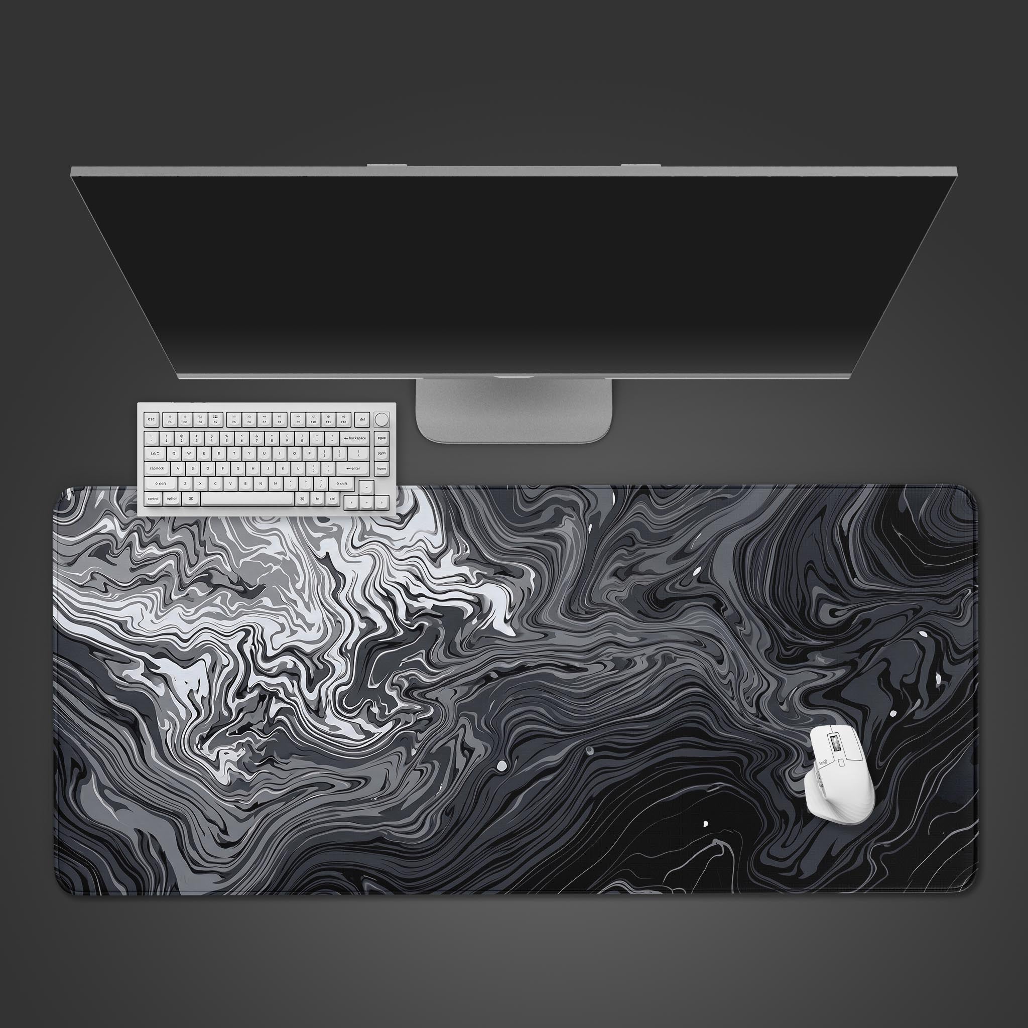 A sleek black, white, and grey abstract fluid marble desk mat laid flat.