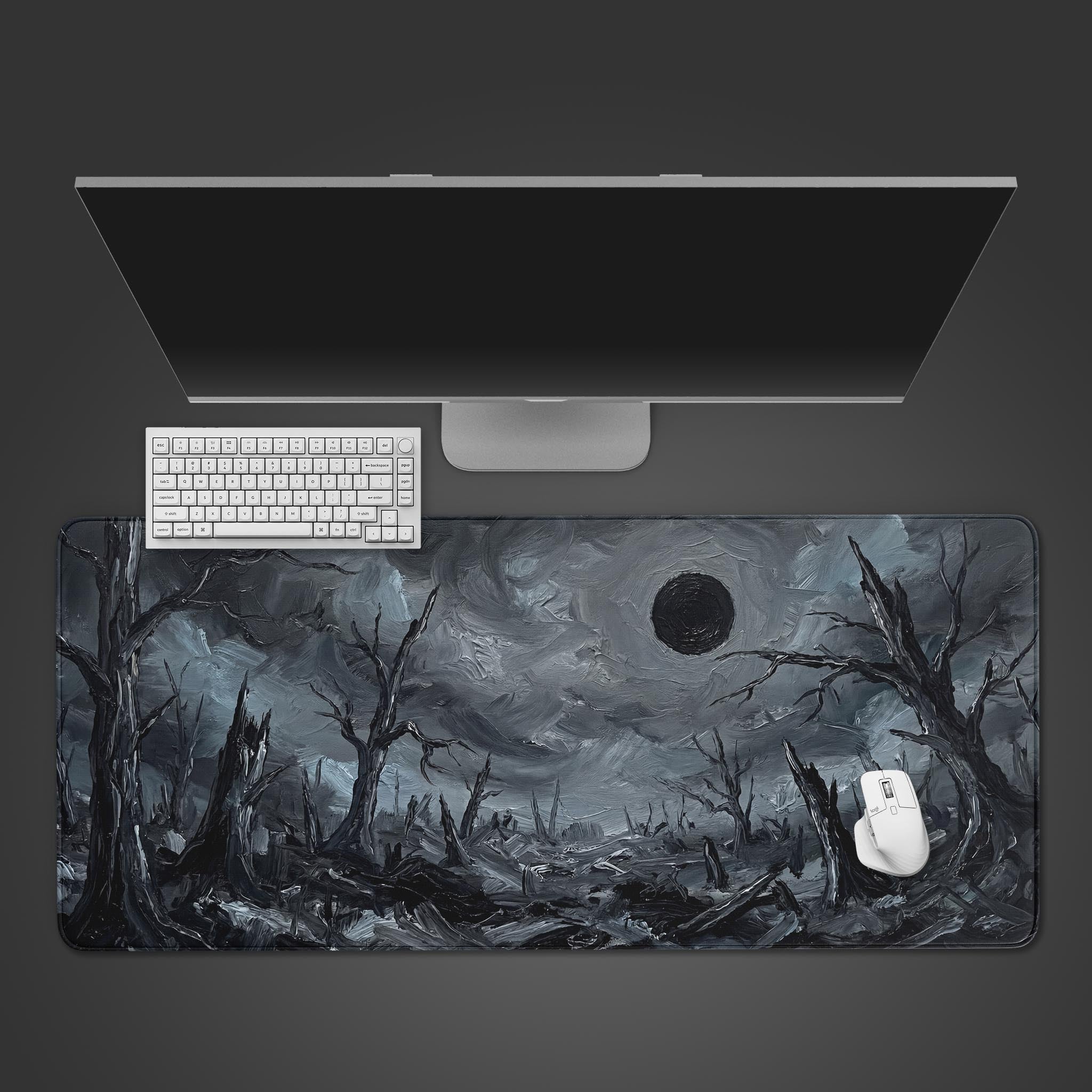 Top-down view of the Eclipse of Ash gaming desk mat, showing its dark fantasy landscape design alongside a white keyboard, mouse, and a sleek monitor. - Epic Design Pads & Mousepads