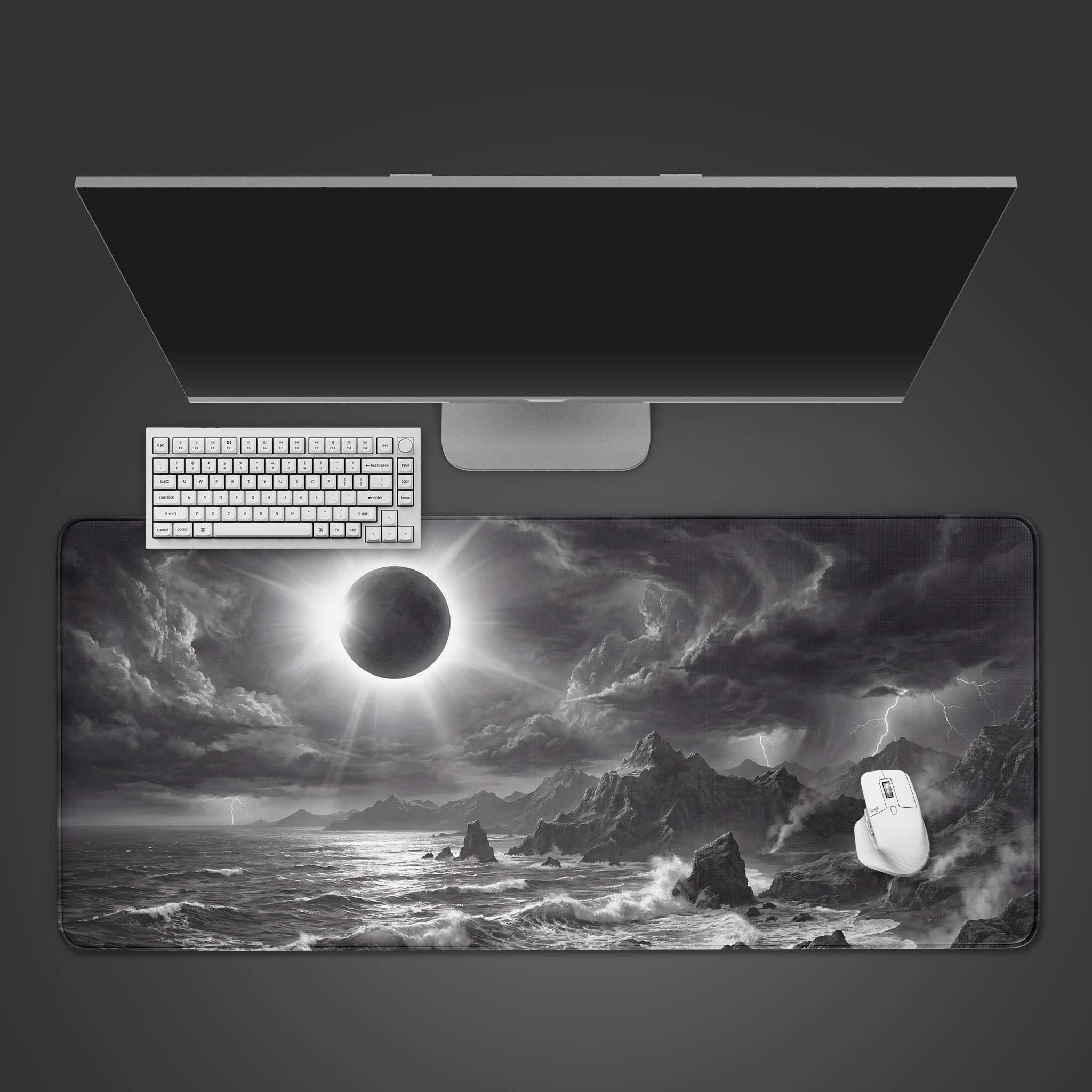 The Eclipse Storm gaming desk mat shown from a top-down view with a white keyboard and mouse, featuring a monochrome solar eclipse design over a stormy sea. - Epic Design Pads & Mousepads