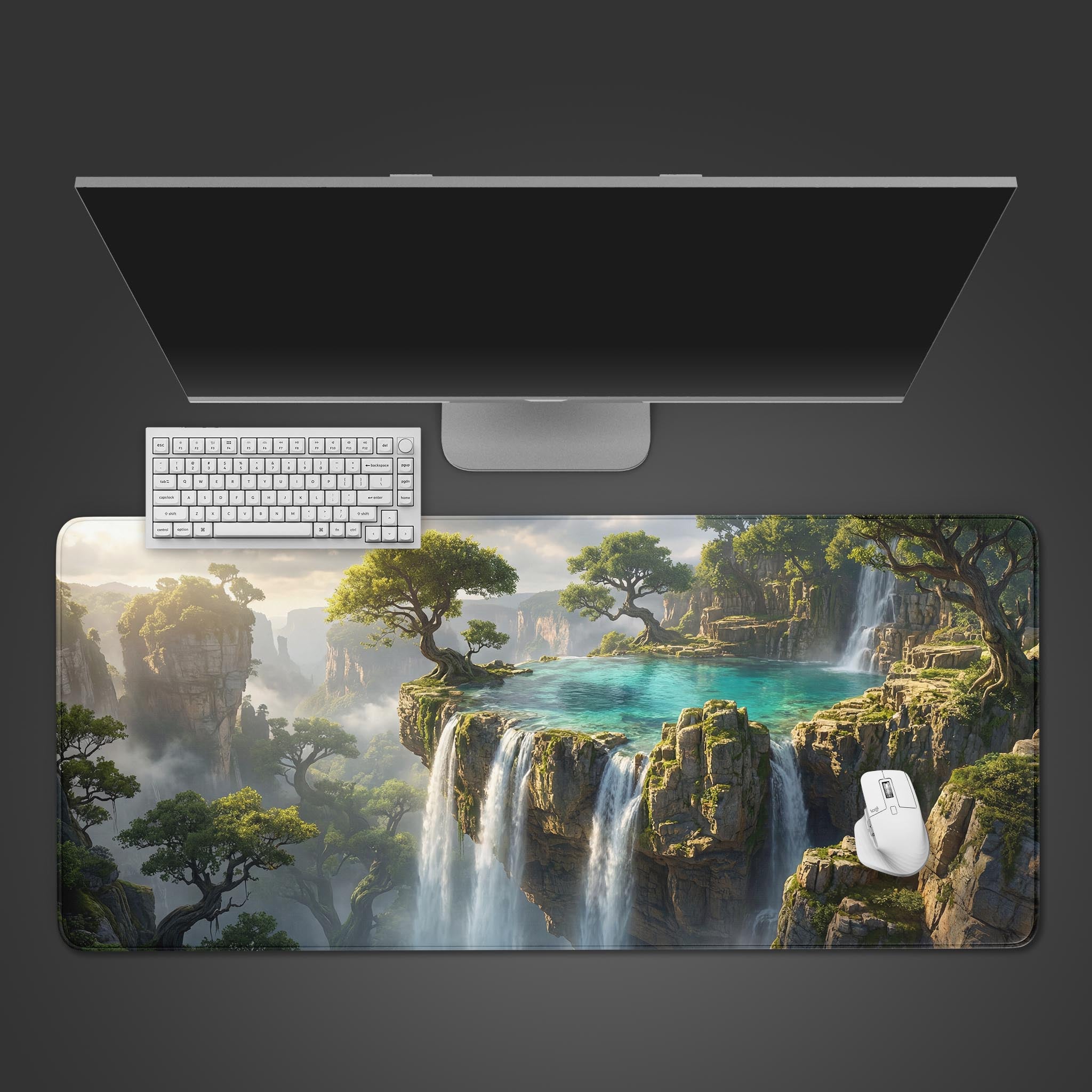Top-down view of the Emerald Cascade gaming desk mat, showing its fantasy waterfall design alongside a white keyboard, mouse, and a sleek monitor on a gray surface. - Epic Design Pads & Mousepads