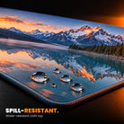 Custom desk mat close-up: water beading on the spill-resistant printed cloth top, stitched edge