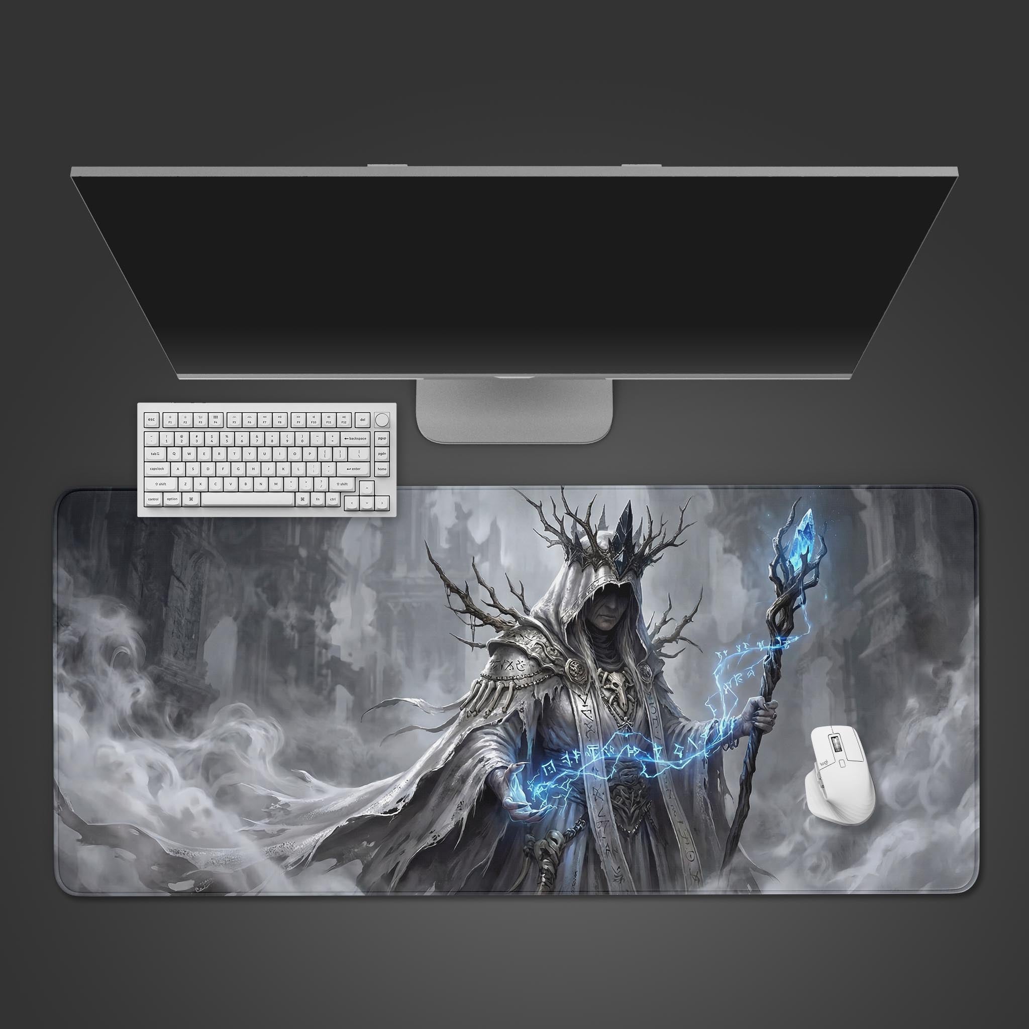 Top-down view of the Frostbound Lich gaming desk mat. A white keyboard and mouse are placed on the dark fantasy artwork, below a sleek monitor. - Epic Design Pads & Mousepads