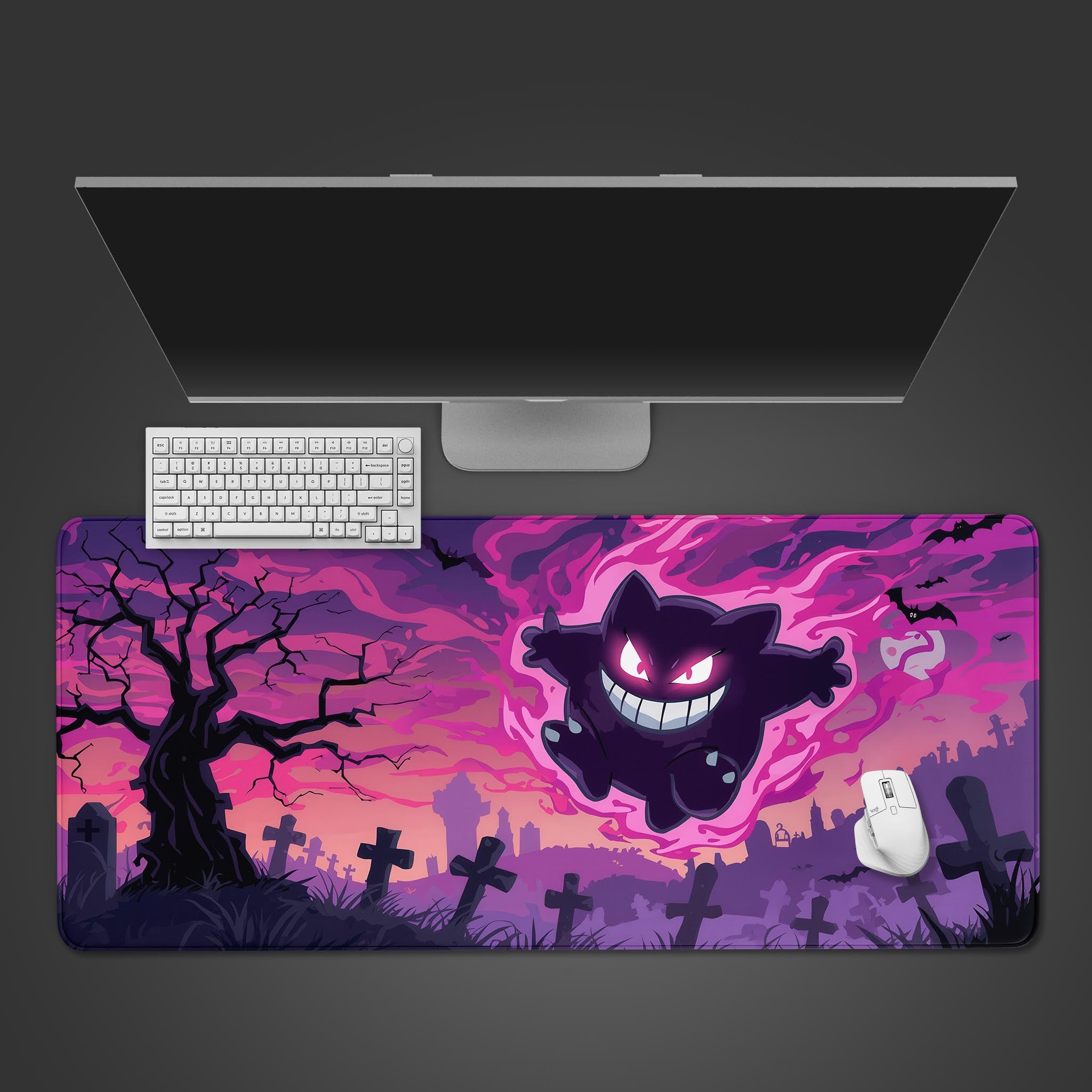 Desk setup with a dark-themed mouse pad featuring a ghost-like character, keyboard, and mouse on a black background.
