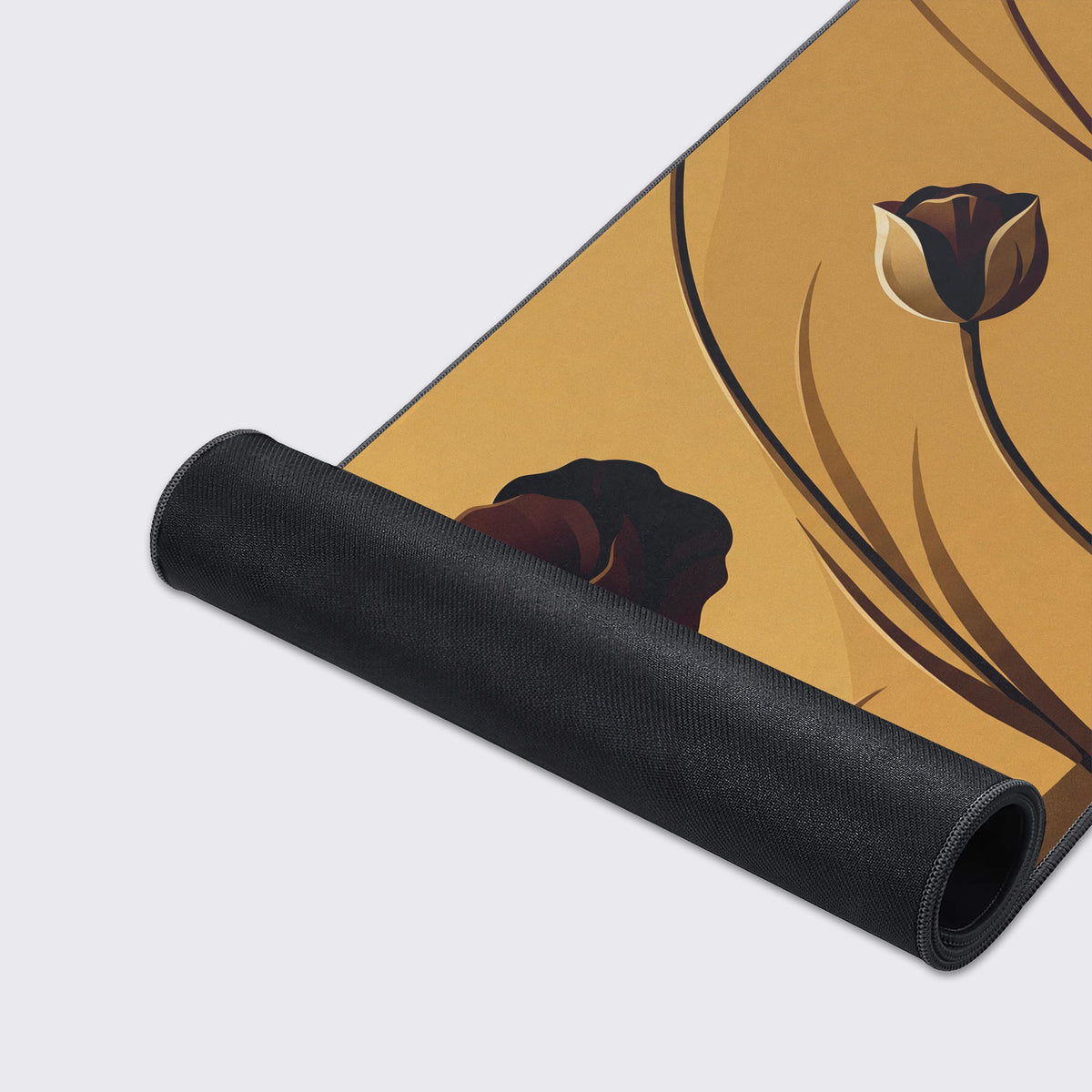 Rolled-up corner of the golden poppy mat showing its black rubber underside below a dark brown flower and a cream bud