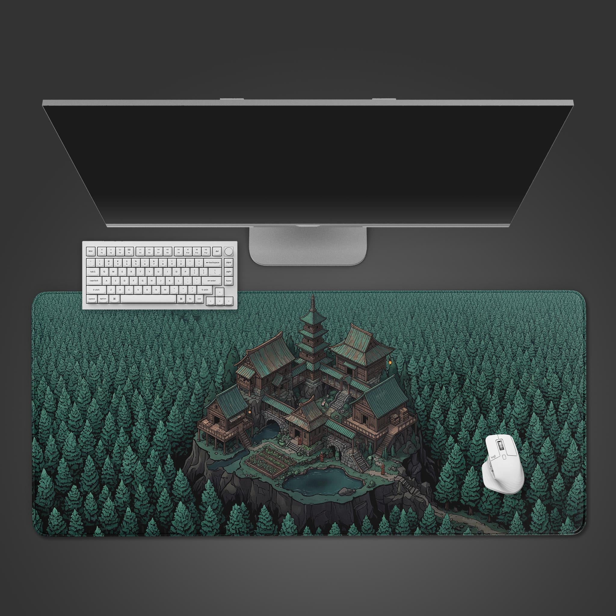 A top-down view of the Hidden Enclave gaming desk mat featuring a Japanese mountain sanctuary, shown with a white keyboard, mouse, and a large monitor on a grey desk. - Epic Design Pads & Mousepads