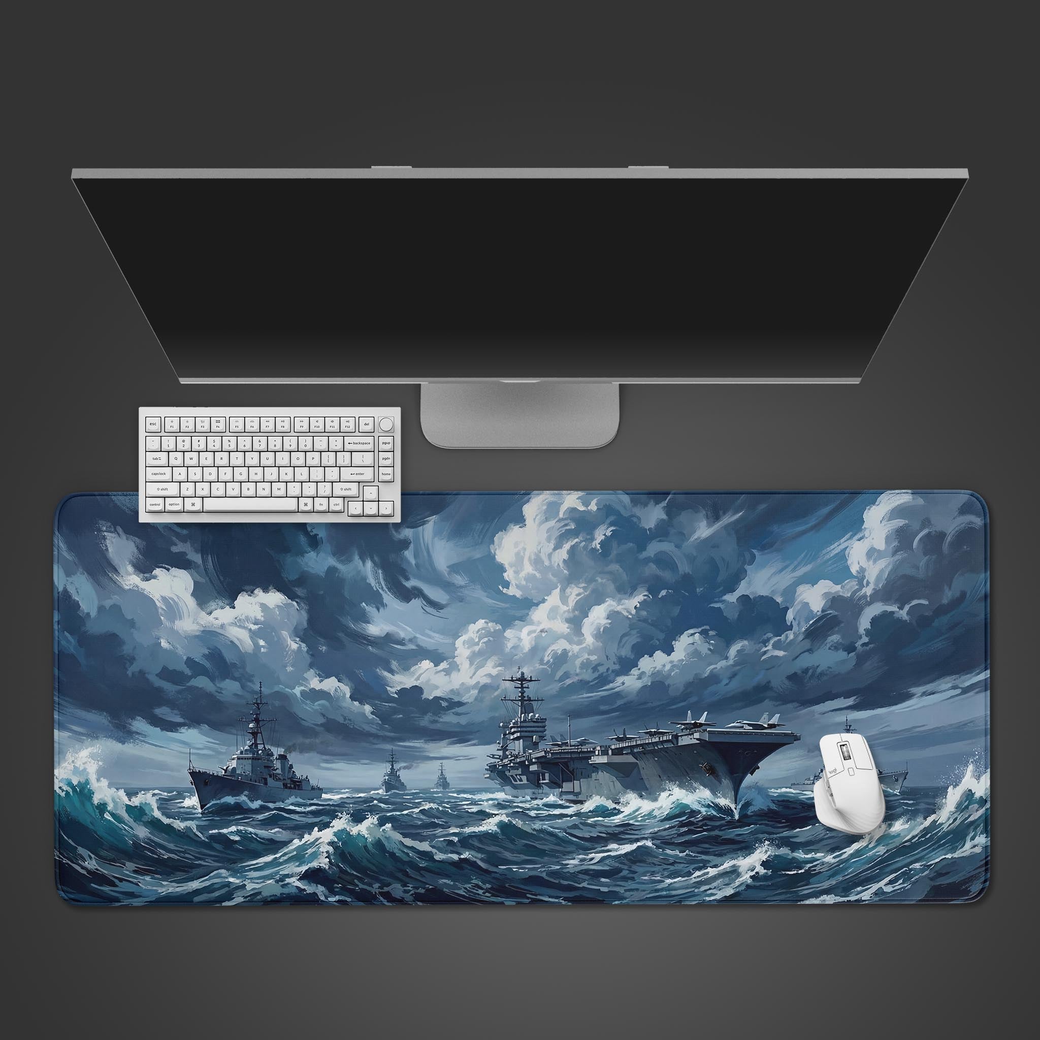 Top-down view of the Iron Fleet gaming desk mat, featuring a naval carrier battle group on a stormy sea. A white keyboard and mouse are positioned on the mat below a monitor. - Epic Design Pads & Mousepads
