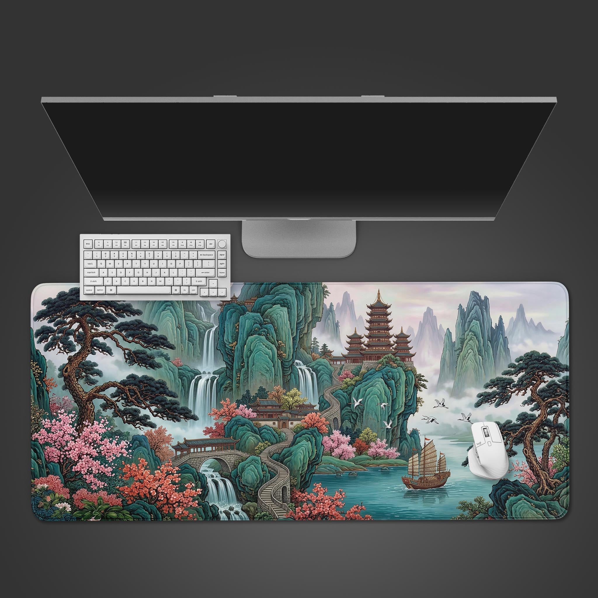 Top-down view of the Jade Peak Retreat Gaming Desk Mat, featuring a Chinese landscape with mountains and waterfalls, shown with a white keyboard and mouse. - Epic Design Pads & Mousepads