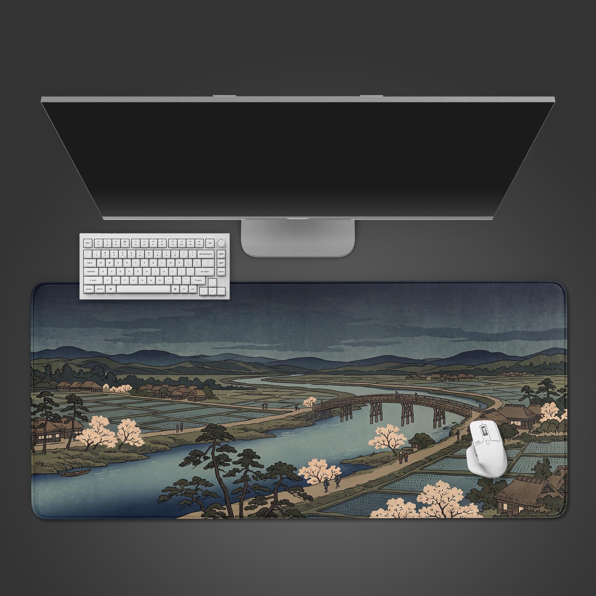 A desk mat featuring a traditional Japanese ukiyo-e landscape with a river, bridge, and cherry blossoms