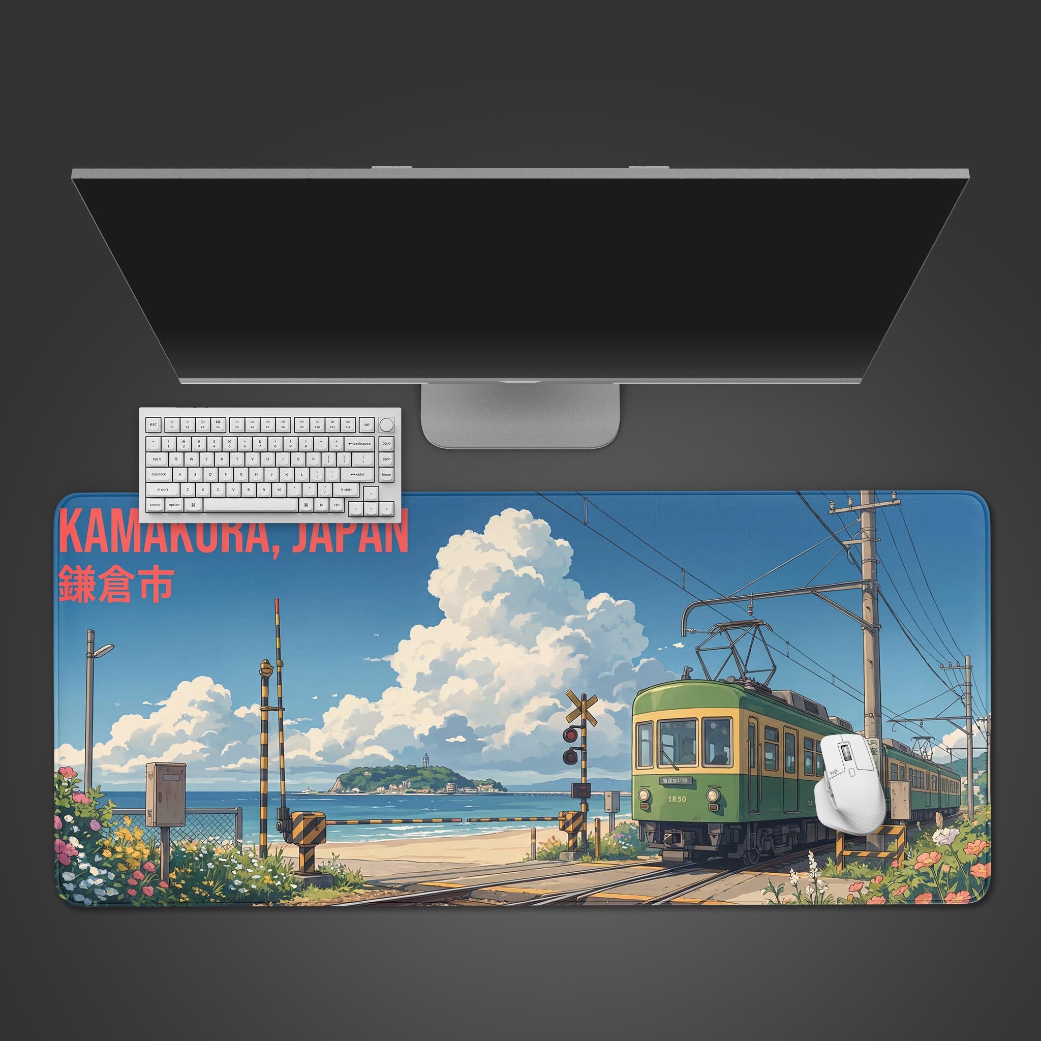 The Kamakura Coast Gaming Desk Mat shown on a desk with a white keyboard and mouse. The anime design features a green train by the sea. - Epic Design Pads & Mousepads