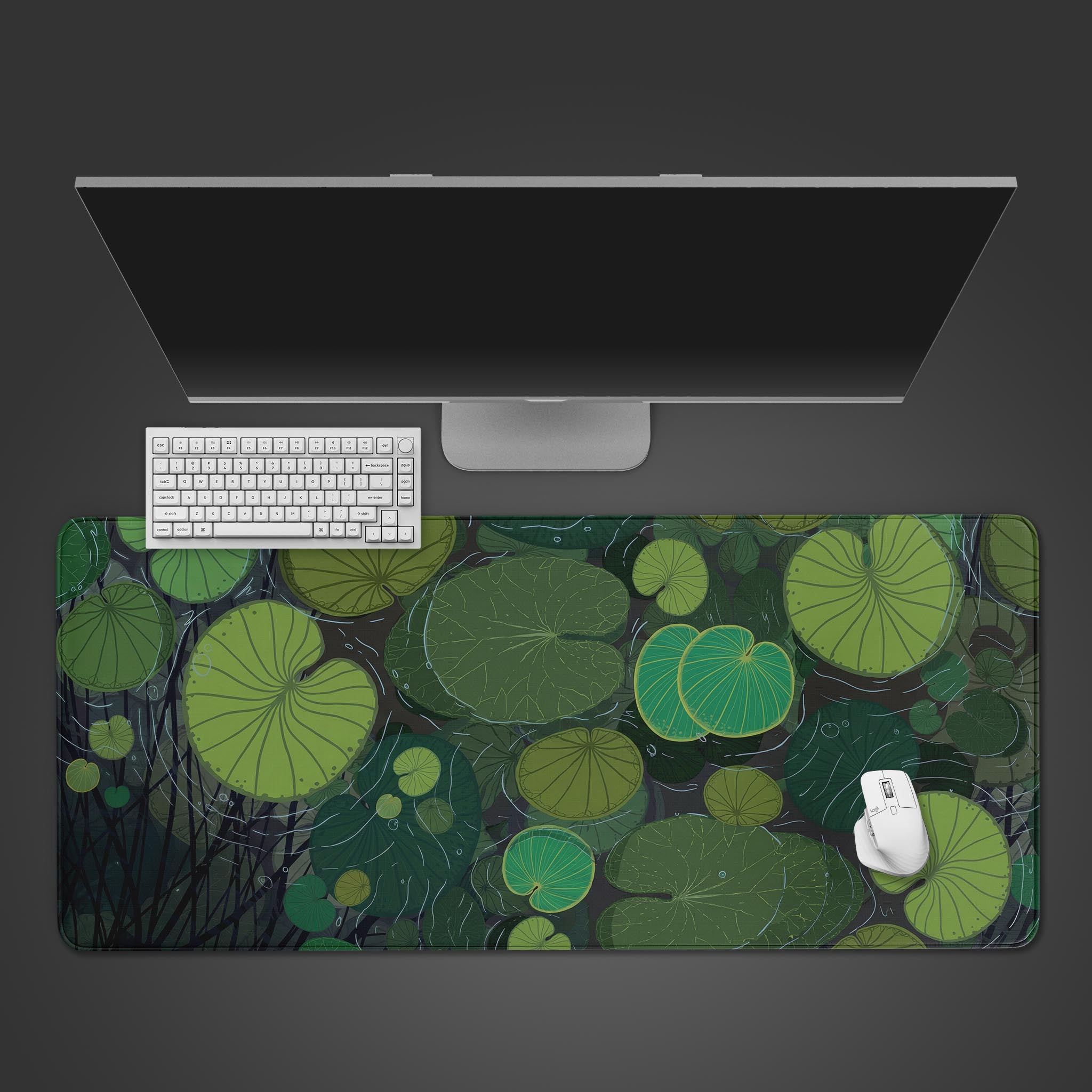 Top-down view of the Lily Pads gaming desk mat featuring a serene green plant design, shown with a white keyboard, mouse, and a large monitor on a dark surface. - Epic Design Pads & Mousepads