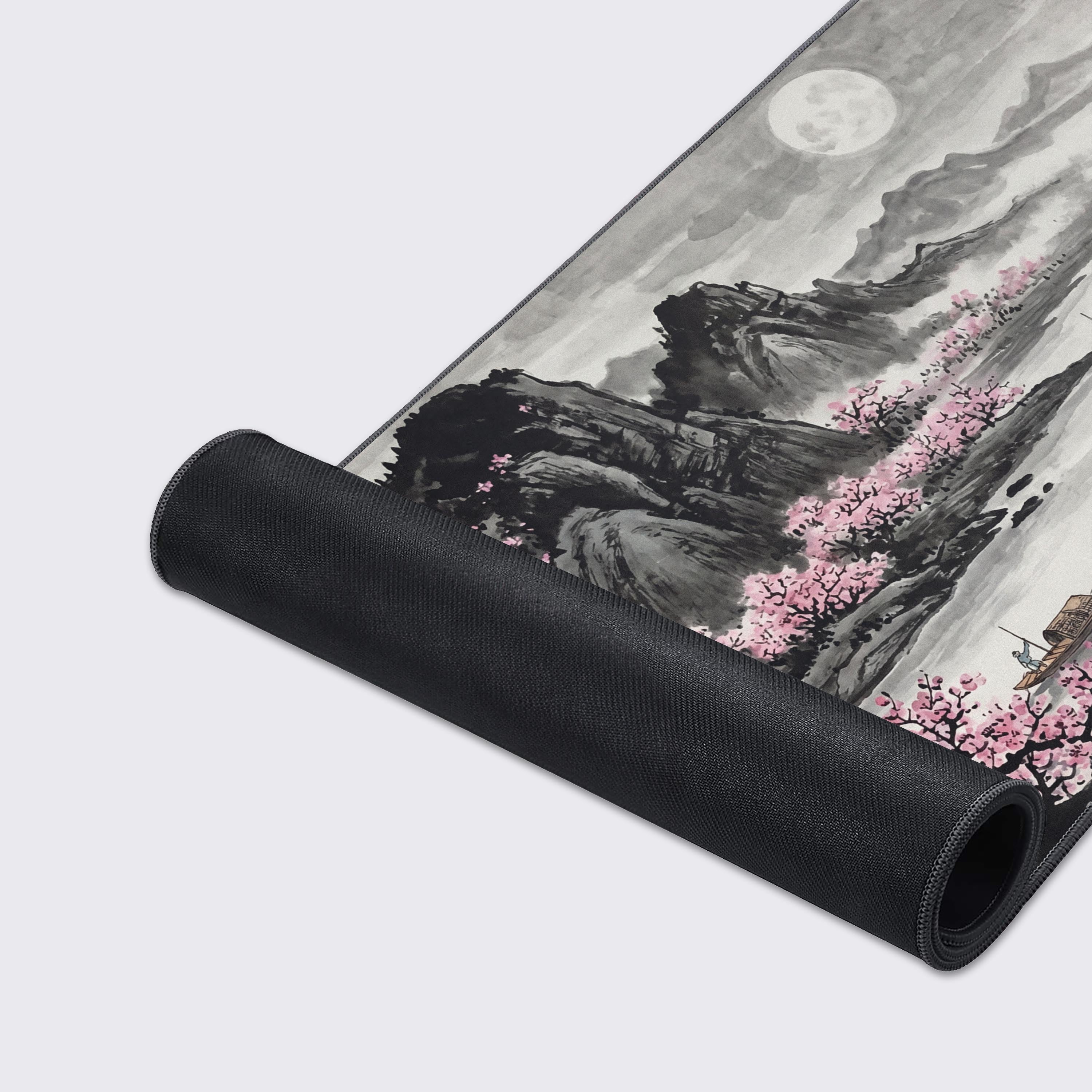 Detailed view of the vibrant pink cherry blossoms contrasting against the monochromatic mountains on the extended desk pad.