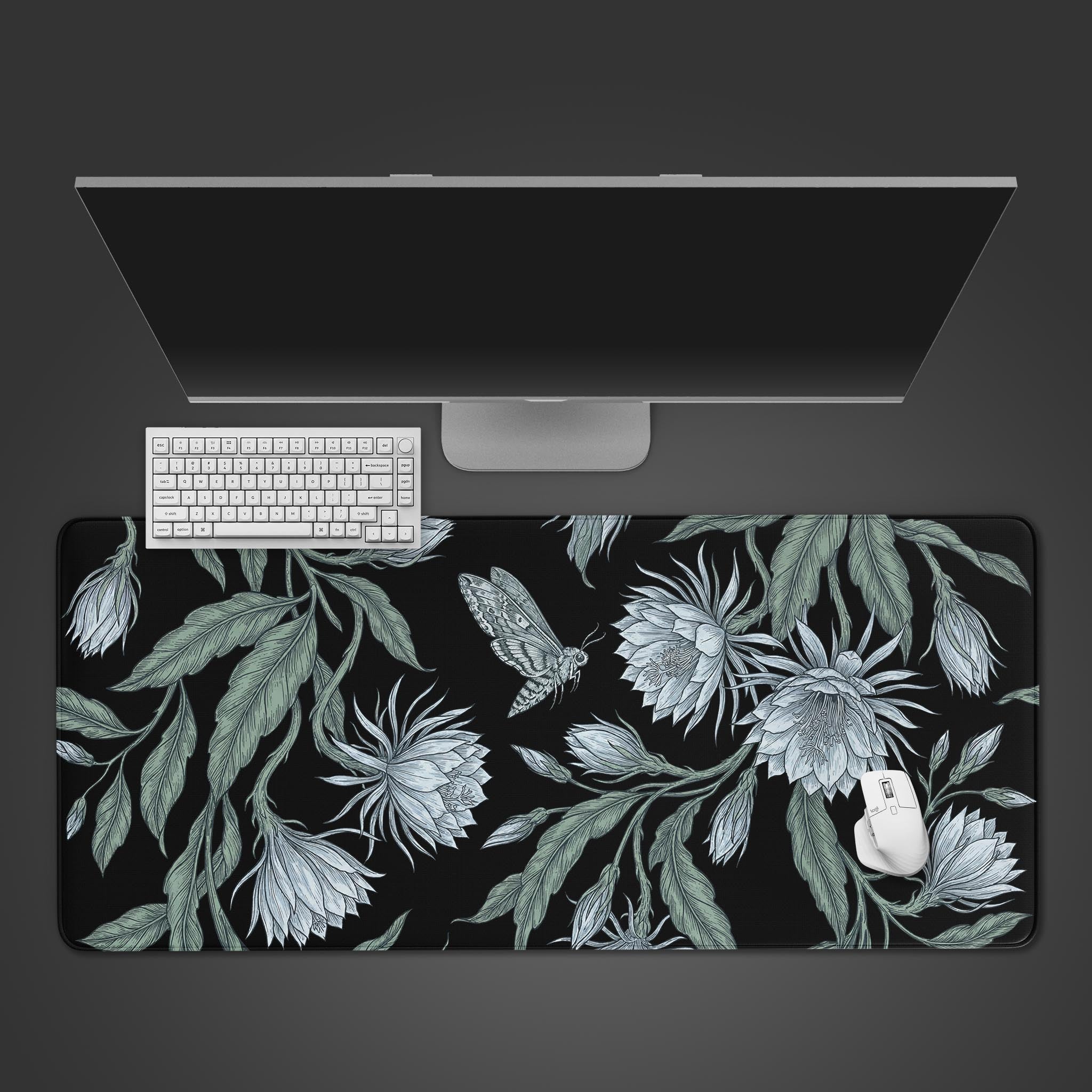 A large desk mat featuring a vintage illustration of a moth and white night-blooming flowers on a black background.