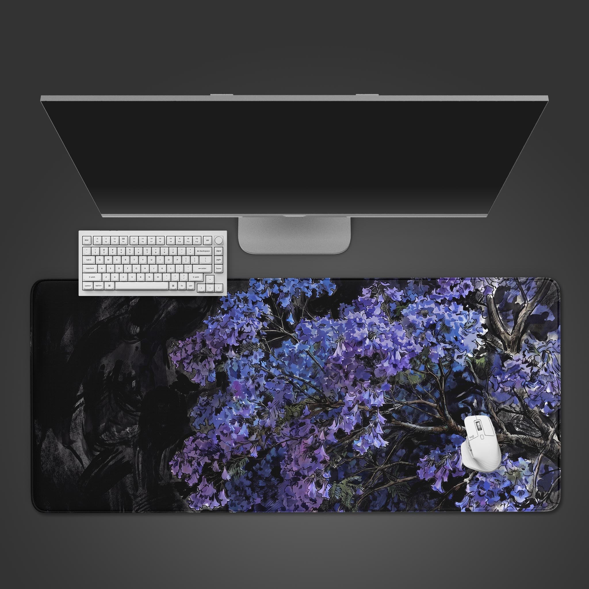 A large extended desk mat featuring a vibrant purple Jacaranda tree against a moody dark background.