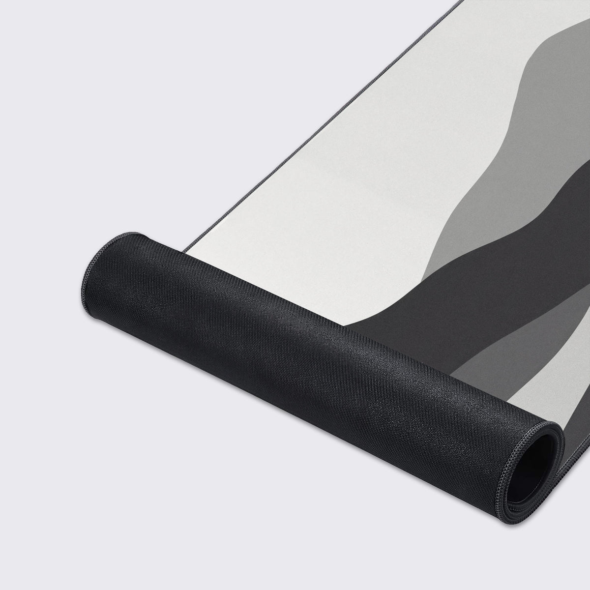 Close-up look at the modern gray and white rolling hills design on a large desk mat.