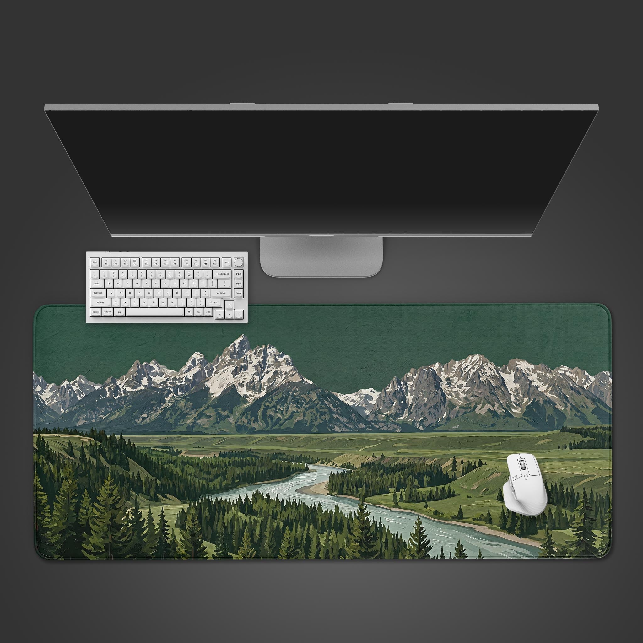 A scenic desk mat featuring a painting of the Grand Tetons mountain range, a winding river, and dense evergreen forests.