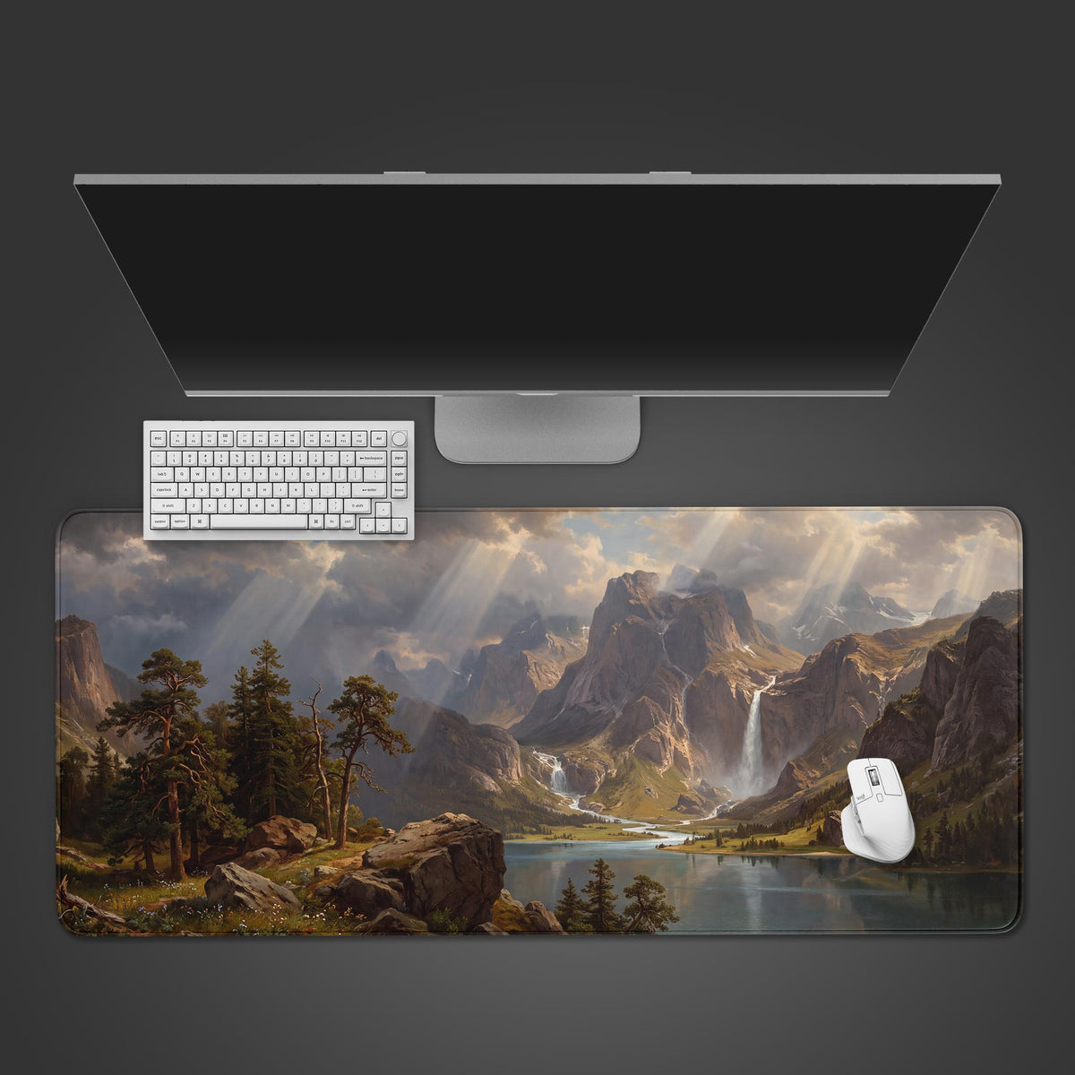 A large desk mat displaying an epic landscape painting of a mountain valley with sunbeams and a waterfall.