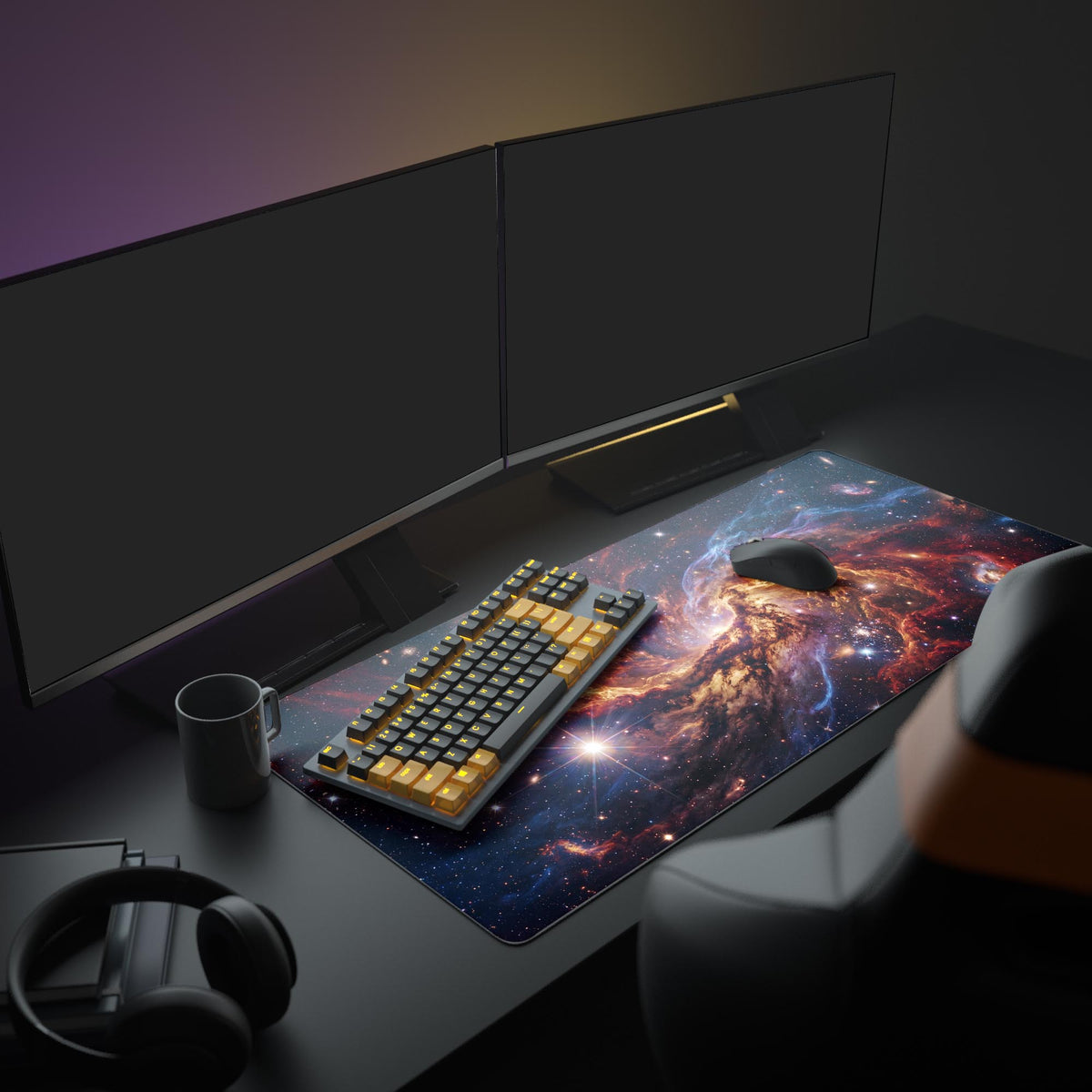 Nebula desk mat on a dark desk with twin monitors, a black and yellow keyboard, mouse, mug and headphones