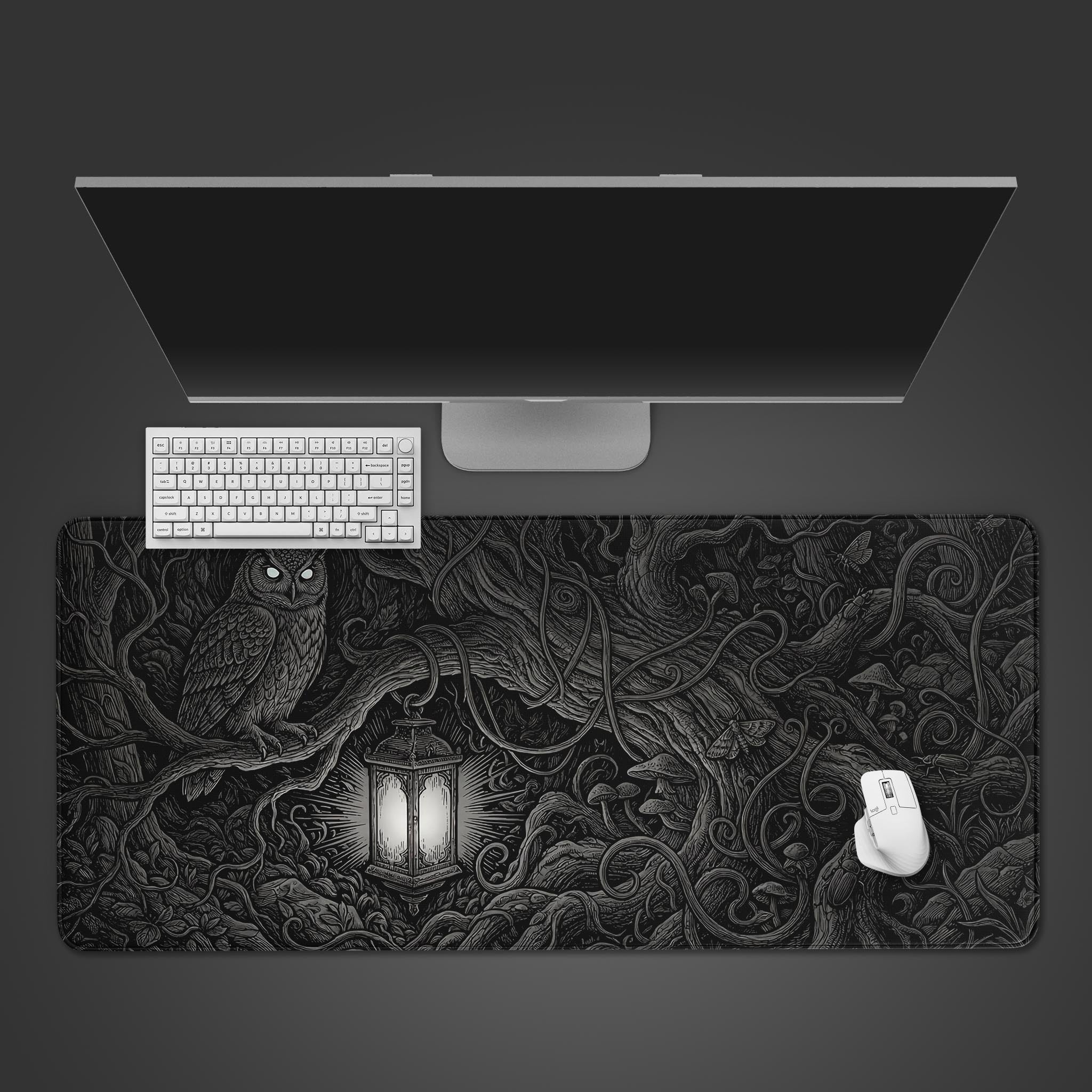 A top-down view of the Nocturnal Roots Gaming Desk Mat, featuring a dark fantasy owl and lantern design, with a white keyboard and mouse. - Epic Design Pads & Mousepads