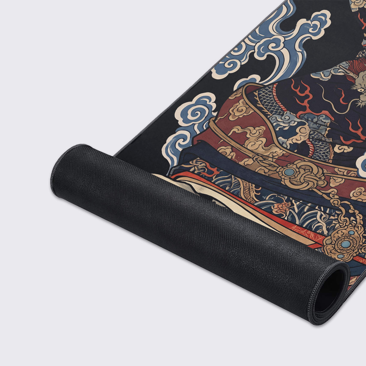 Desk mat partly rolled up, showing black rubber underside beside printed kimono robes, a dragon and blue and cream clouds