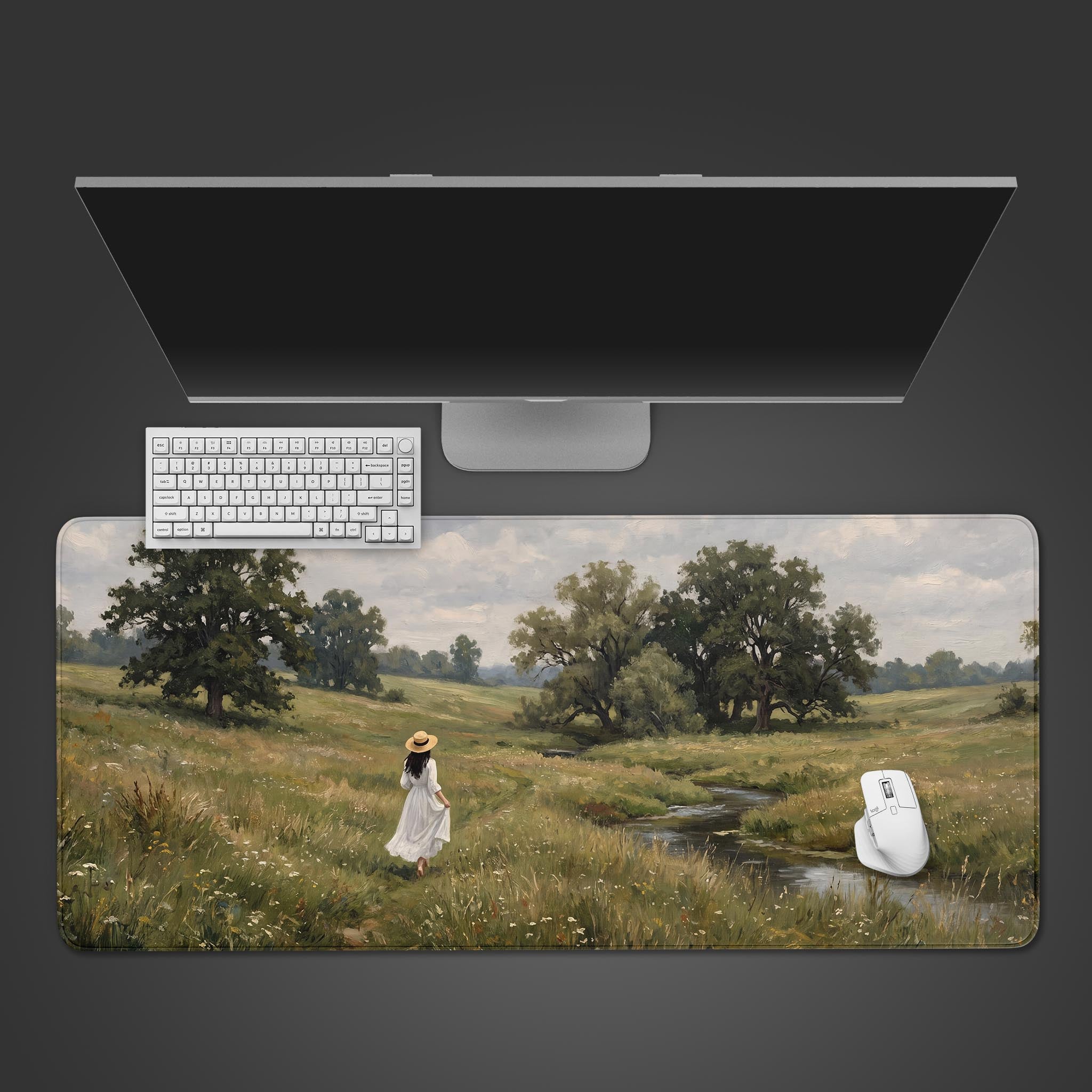 A desk mat displaying a classic oil painting of a woman walking through a lush green meadow next to a stream.